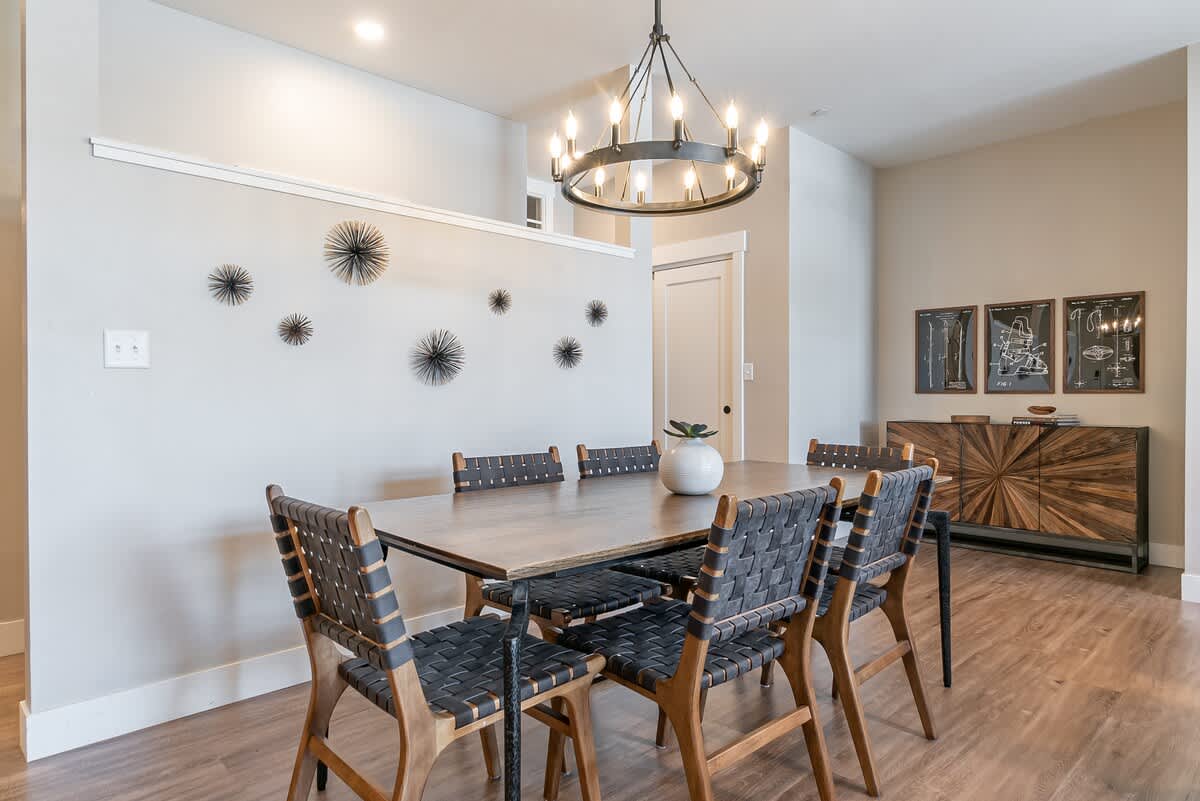 This spacious dining area features a table for 8, modern chandelier lighting, and upscale decor—perfect for shared meals, game nights, or celebrations.