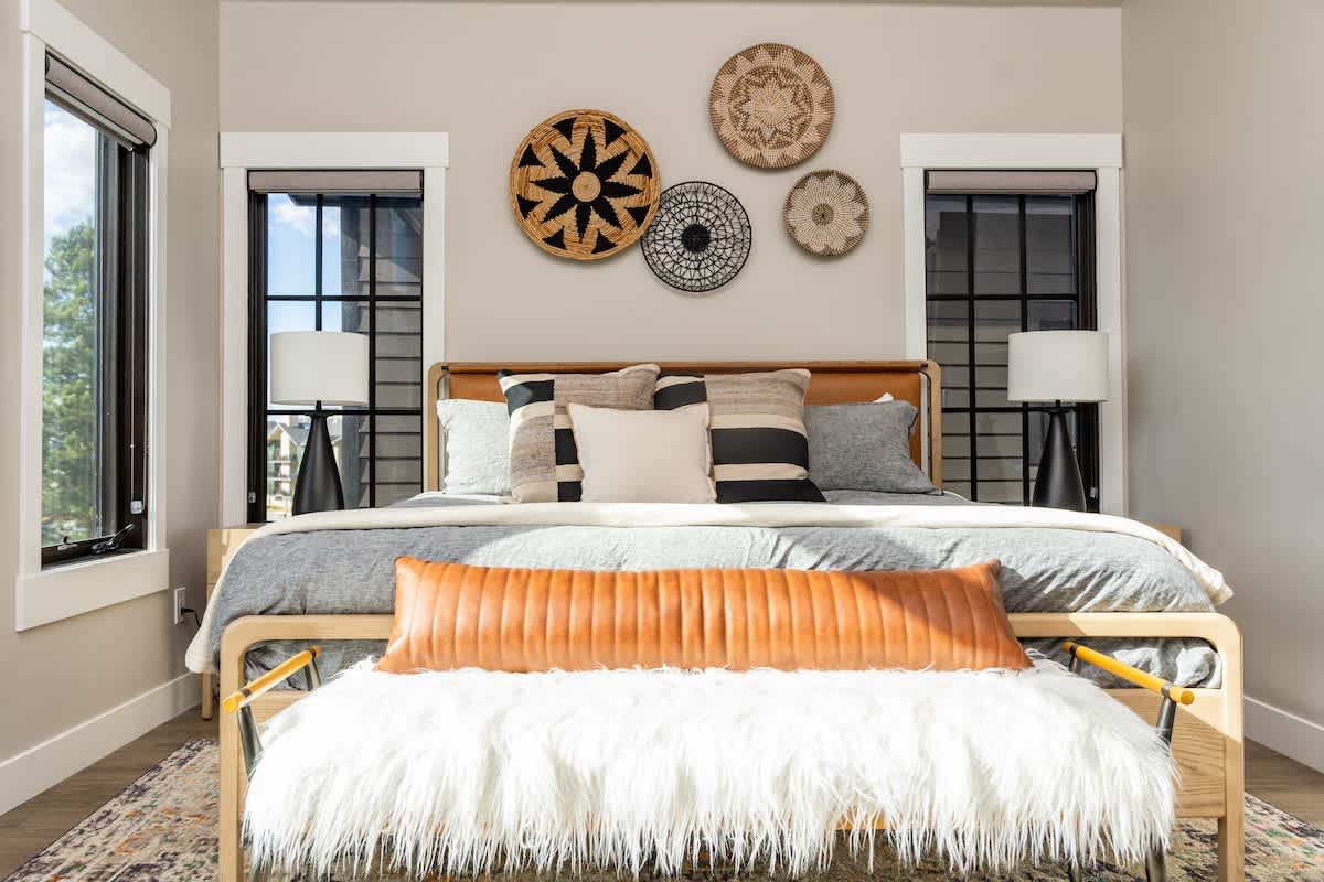 - Bright bedroom with large windows and stylish wall decor above the bed
- Cozy bedding with layered pillows creates a warm inviting retreat
- Modern design blends comfort and elegance in a serene setting
