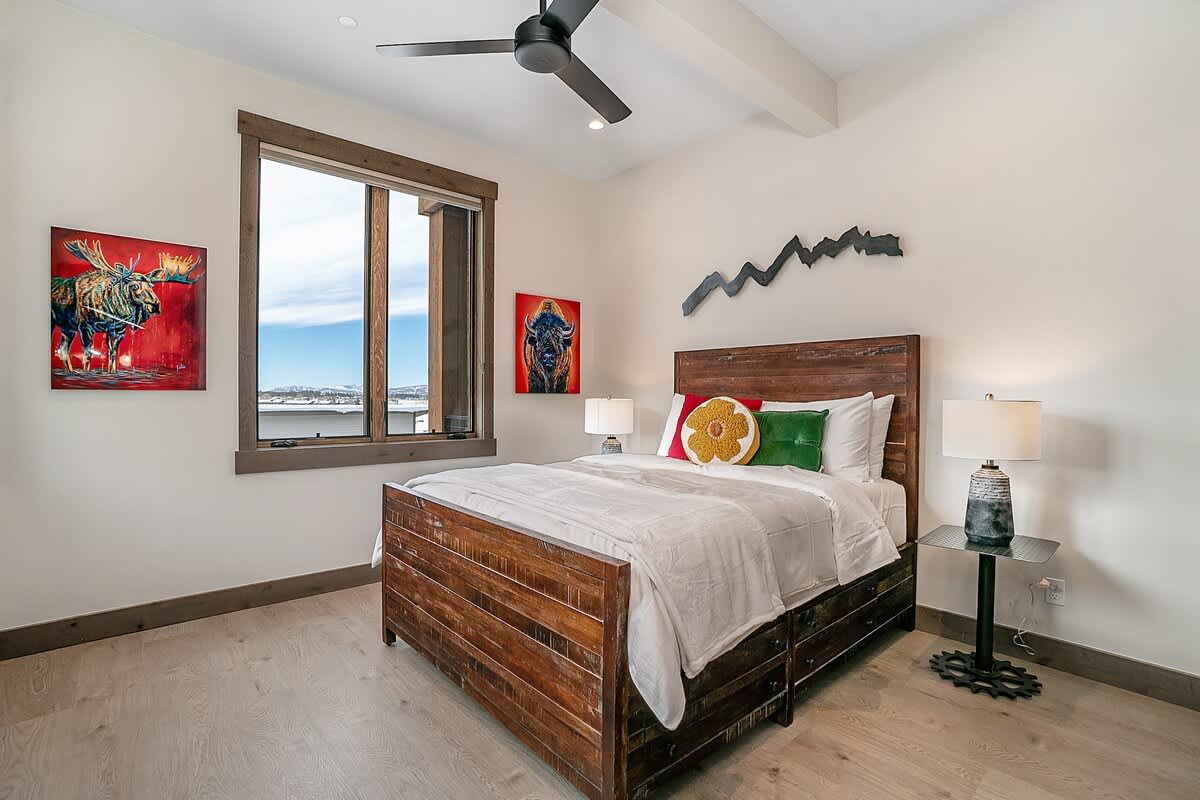 - Bright bedroom with rustic bedframe and scenic mountain views
- Bold artwork adds personality and a vibrant pop of color
- Spacious layout with natural light enhances the inviting feel