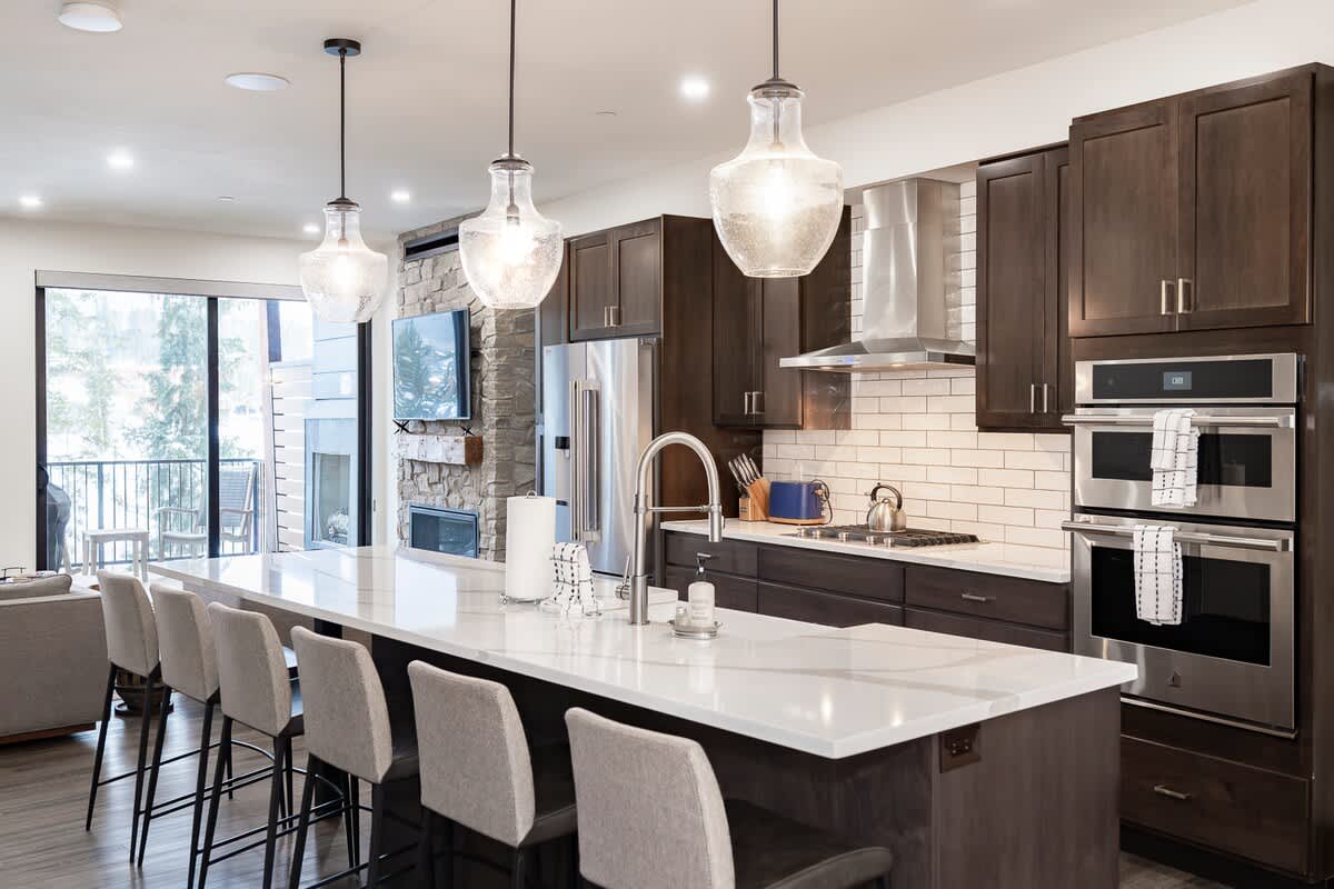 - Gather around the sleek island with plush stools, pendant lights, and spacious flow
- Cook with ease using double ovens, gas range, and stainless appliances
- Fireplace views add warmth and charm while you prep and dine
