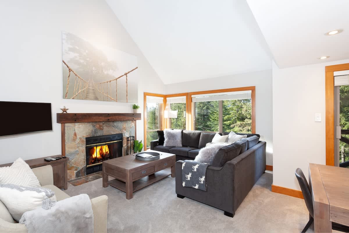 - Bright and modern Whistler living room with cozy fireplace 
- Large windows with forest views for a peaceful retreat 
- Perfect family space for après-ski relaxation 
