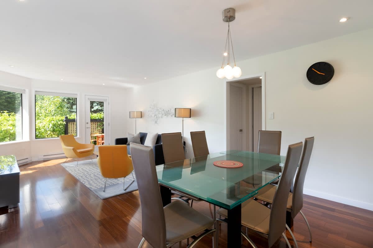 Airy dining space w/ a glass table and modern chairs, ideal for shared meals and easy conversation.