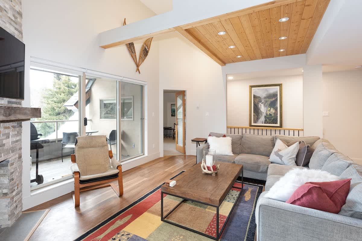 - Cozy living room with fireplace and vaulted wood ceilings for warm evenings 
- Spacious seating and sliding doors opening to a forest-view balcony 
- Perfect blend of comfort, style, and Whistler mountain charm 