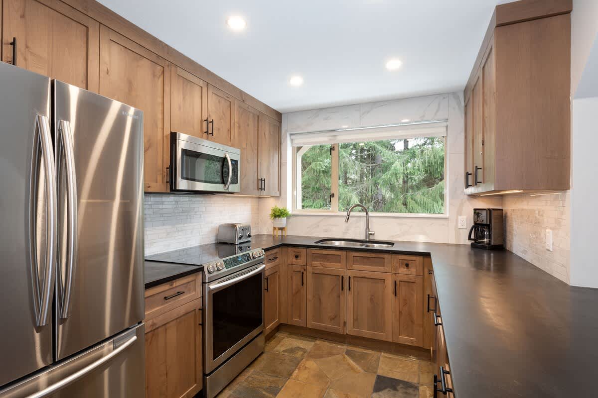 - Modern kitchen with stainless steel appliances and granite counters 
- Rustic wood cabinetry pairs beautifully with forest views outside 
- Fully equipped for extended stays and family cooking moments 
