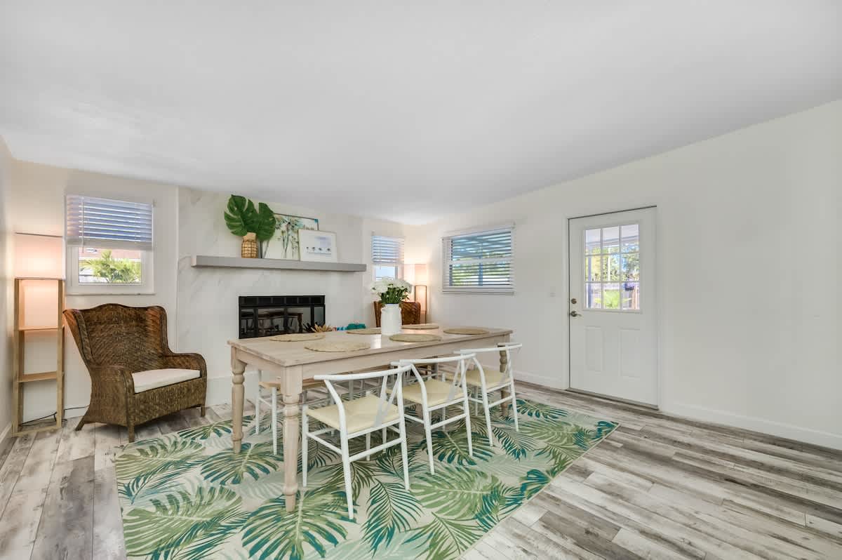 A dining room area featuring a fireplace and a table that accommodates eight people. It's an ideal space for enjoying meals or hosting game nights with friends and family.