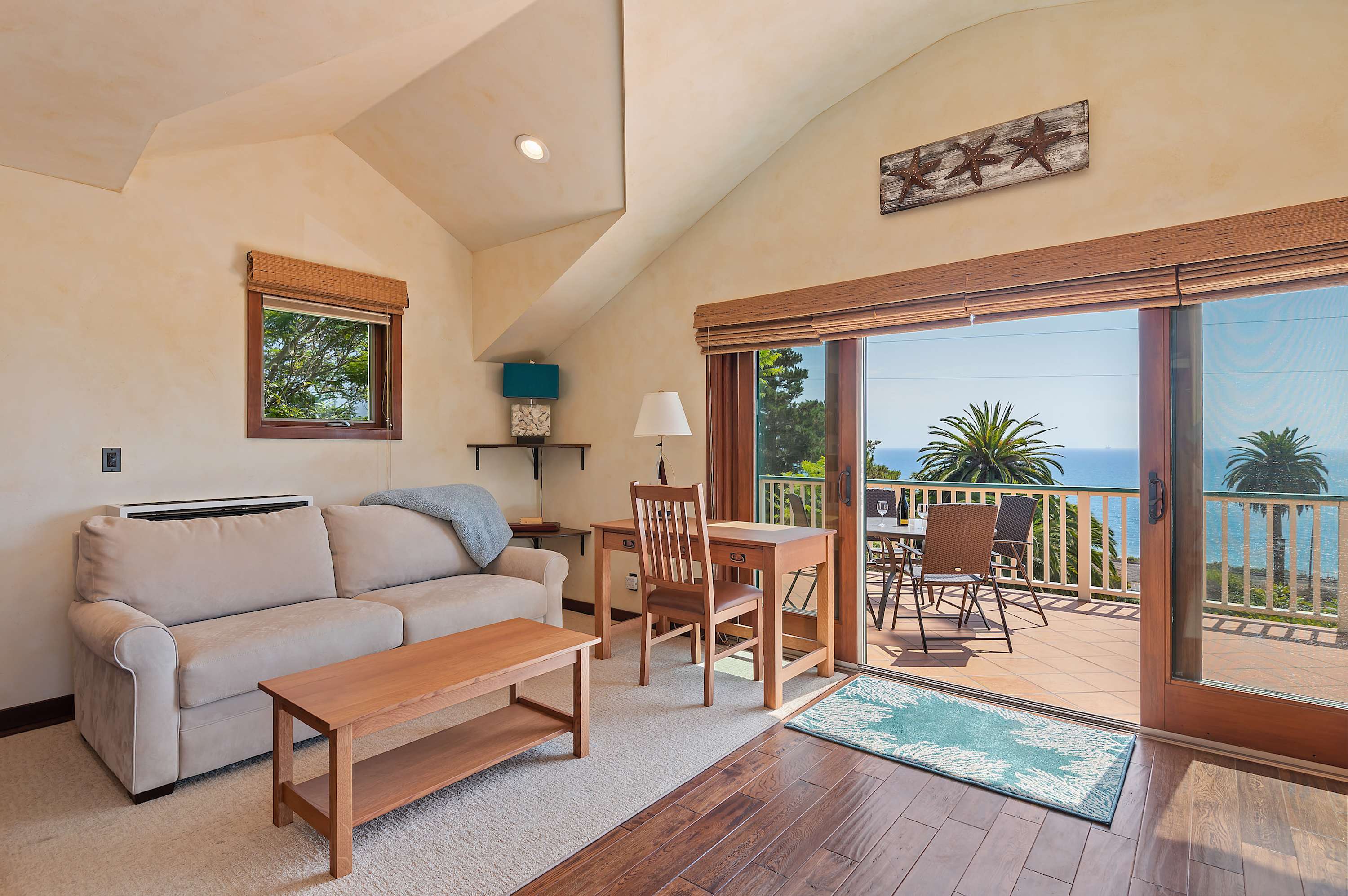 Living room with loveseat, flat screen TV, and ocean view