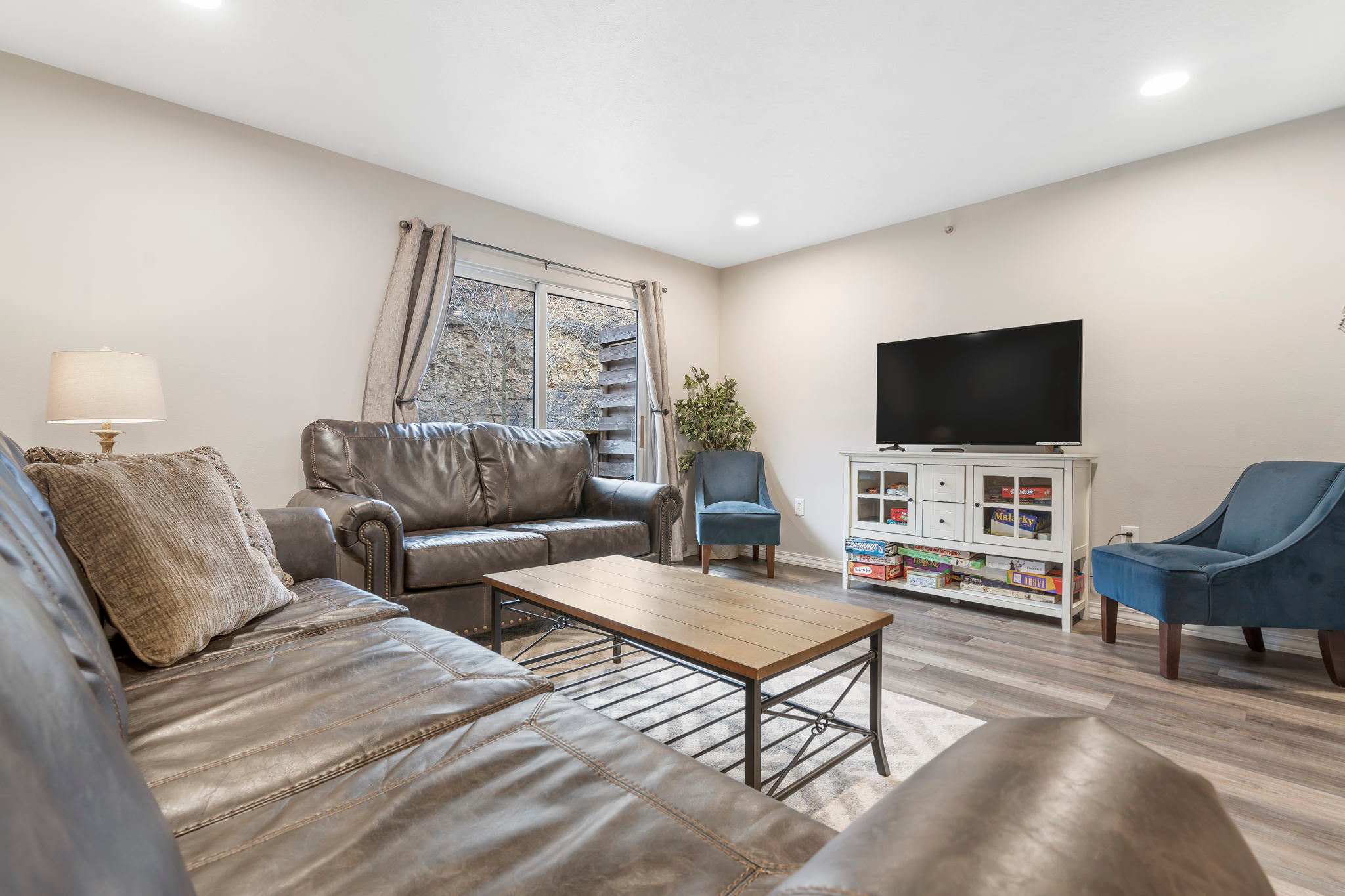 Open living space with TV, and balcony access (Unit #3)