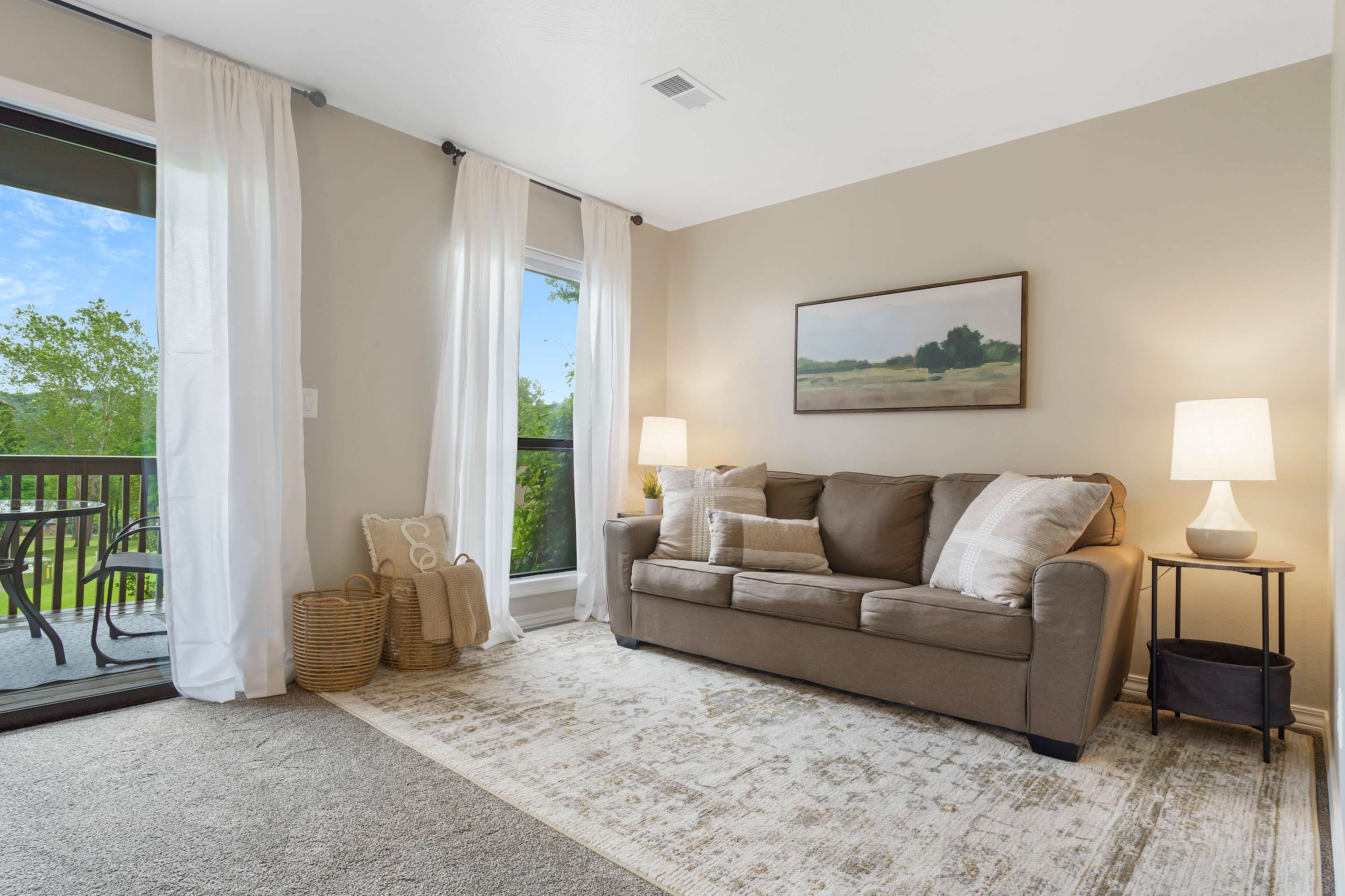 Open living space with sofa sleeper, TV, and balcony access