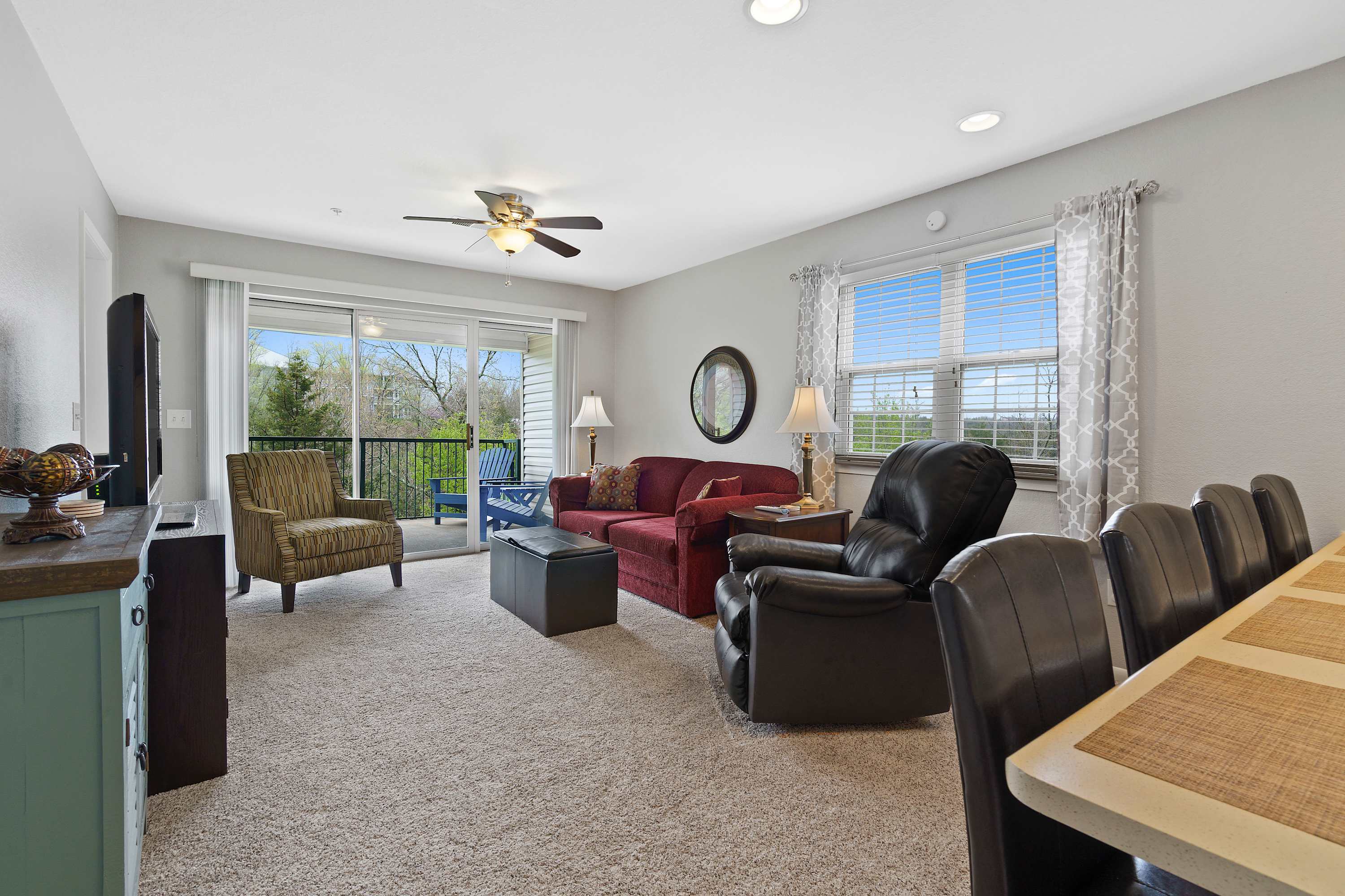 Open living space with sofa sleeper, TV, and balcony access