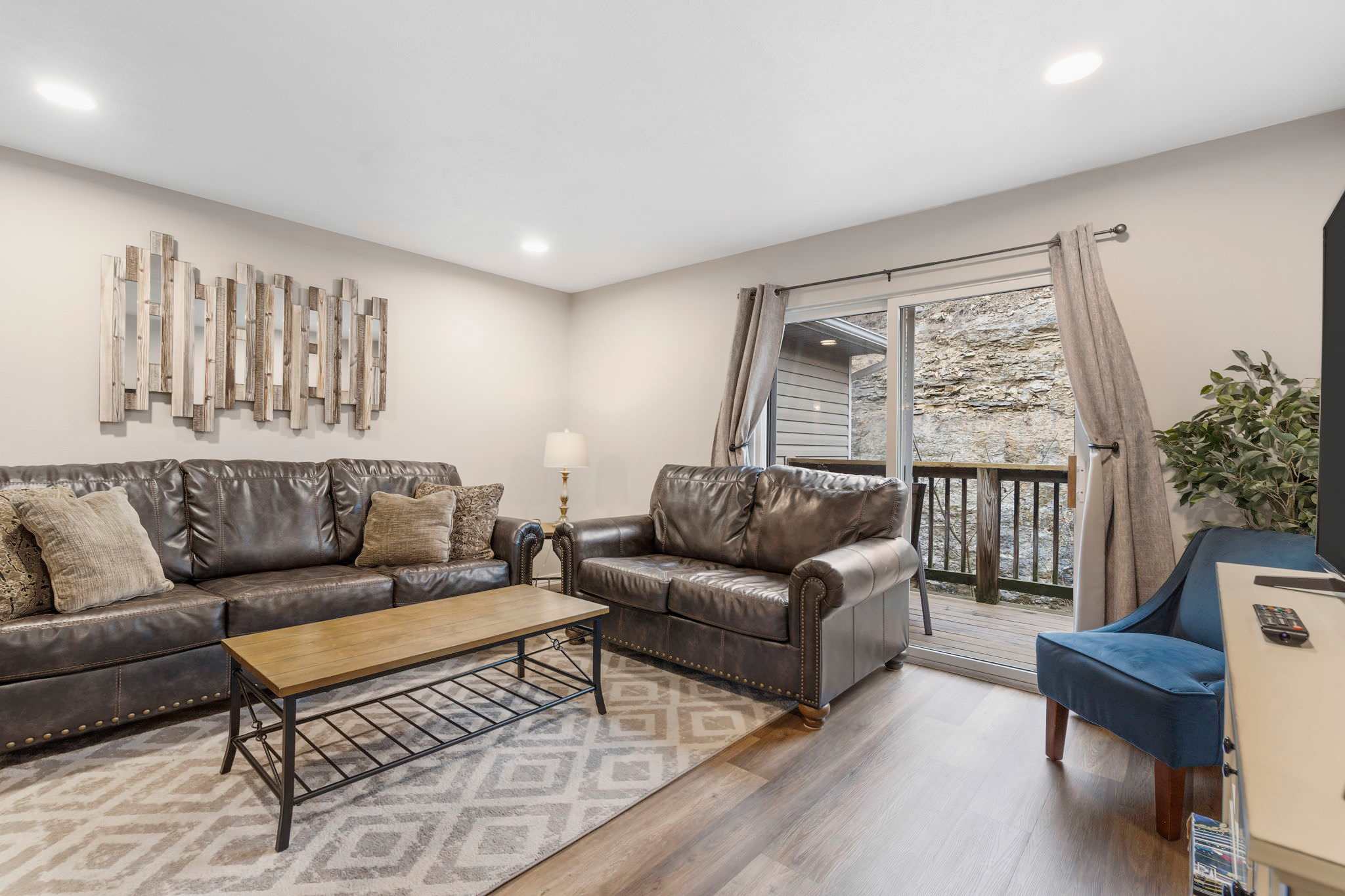 Open living space with TV, and balcony access