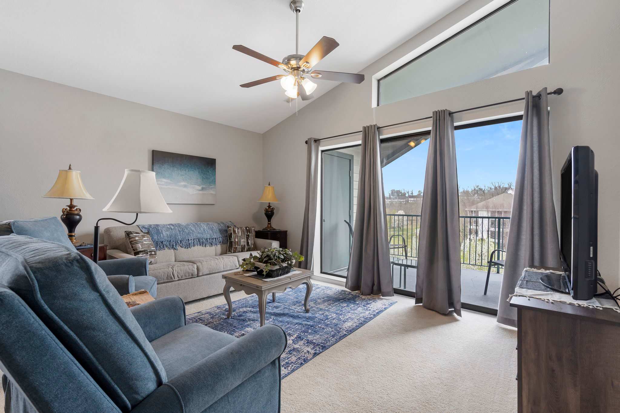 Open living space with Queen sofa sleeper, TV, and balcony access