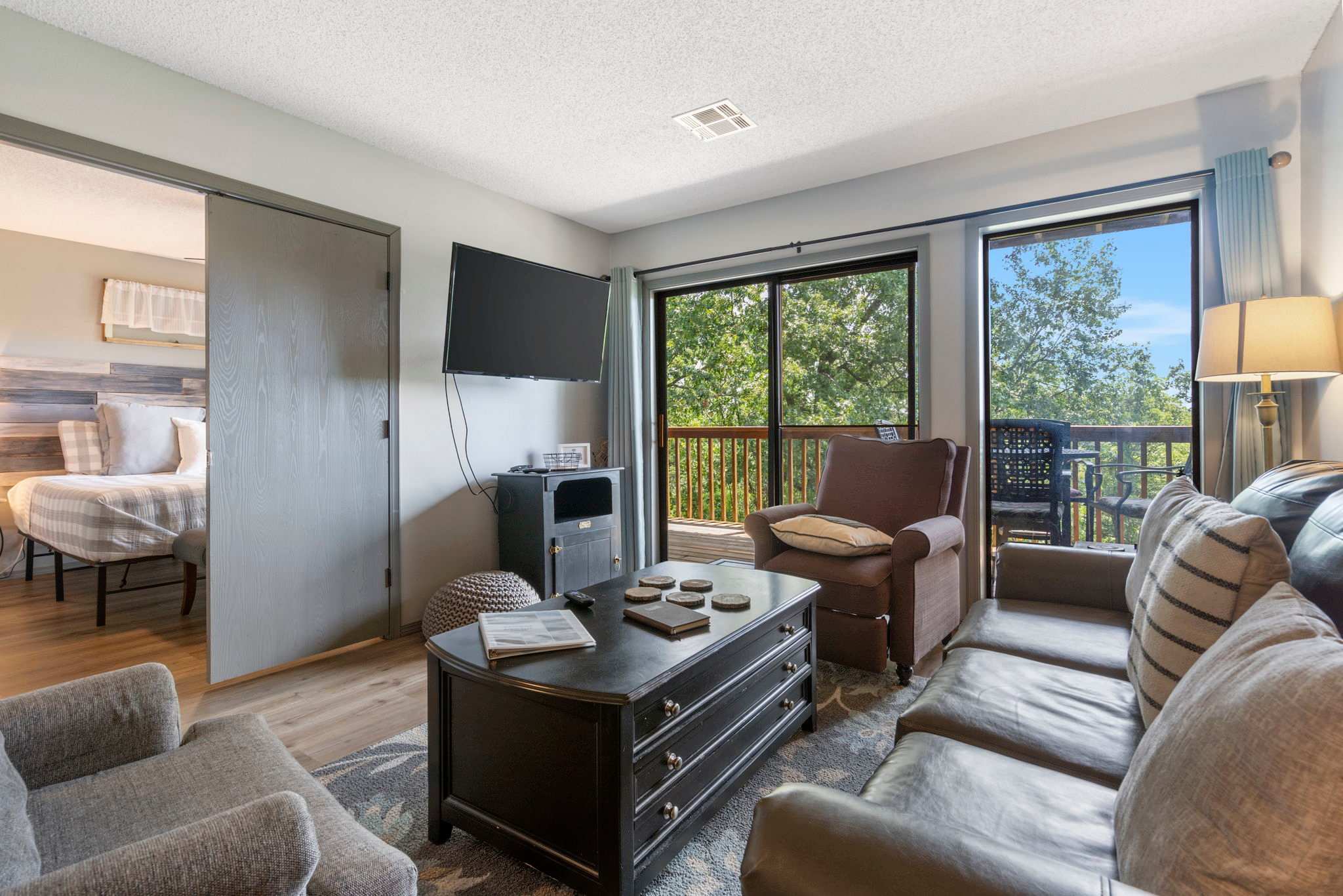 Open living space with Queen sofa sleeper, TV, and deck access