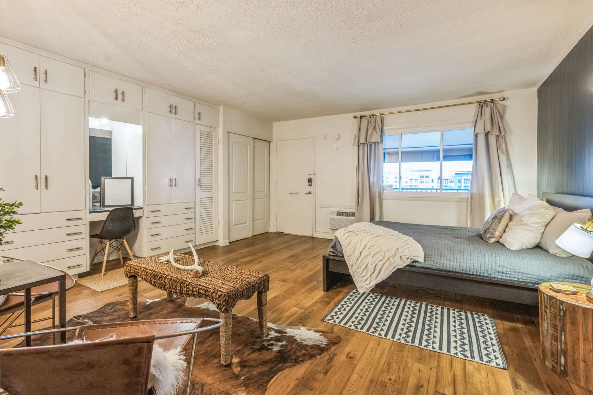 A cozy and stylish studio featuring built-in storage and warm, inviting decor