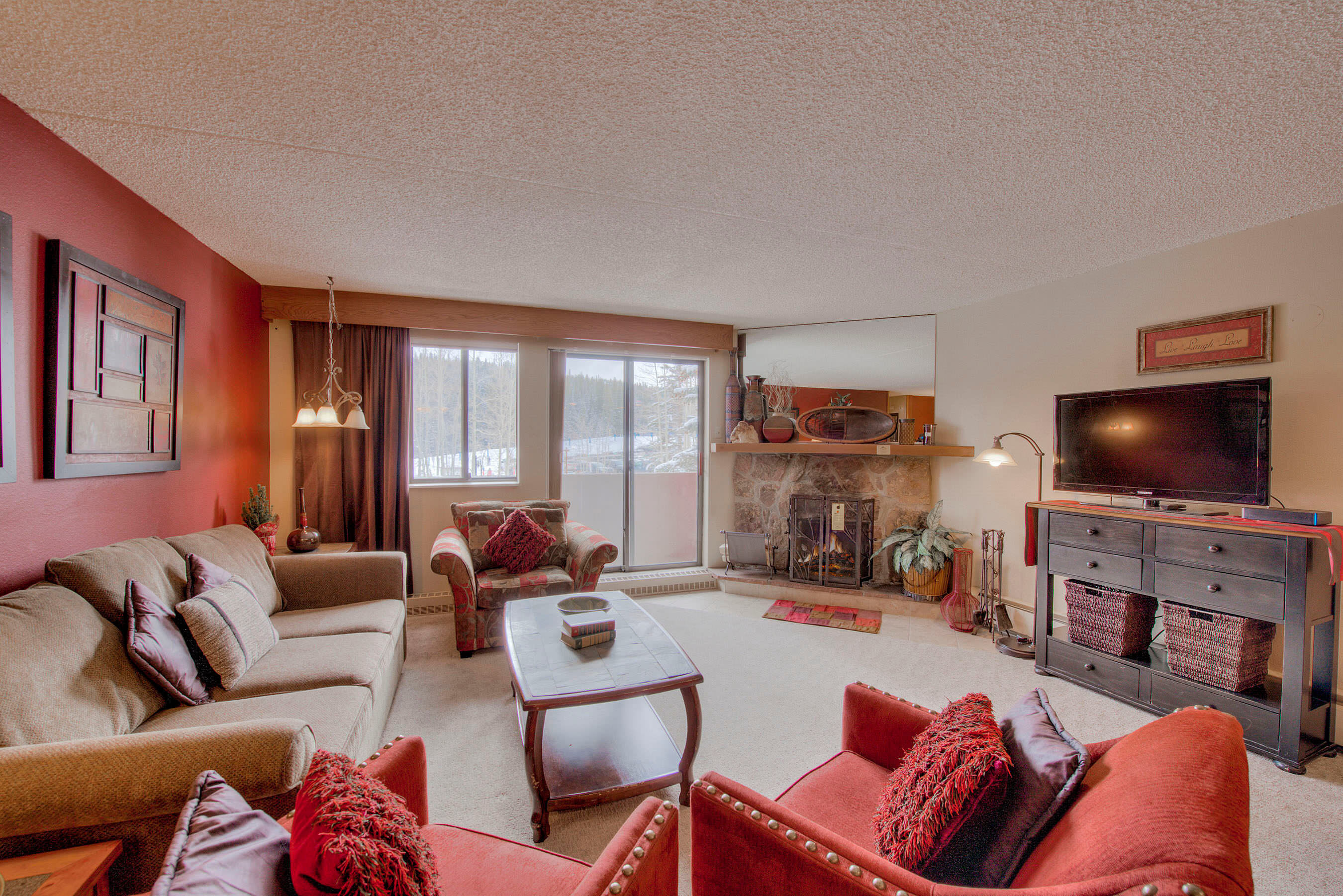 Living room with fireplace, TV and balcony access