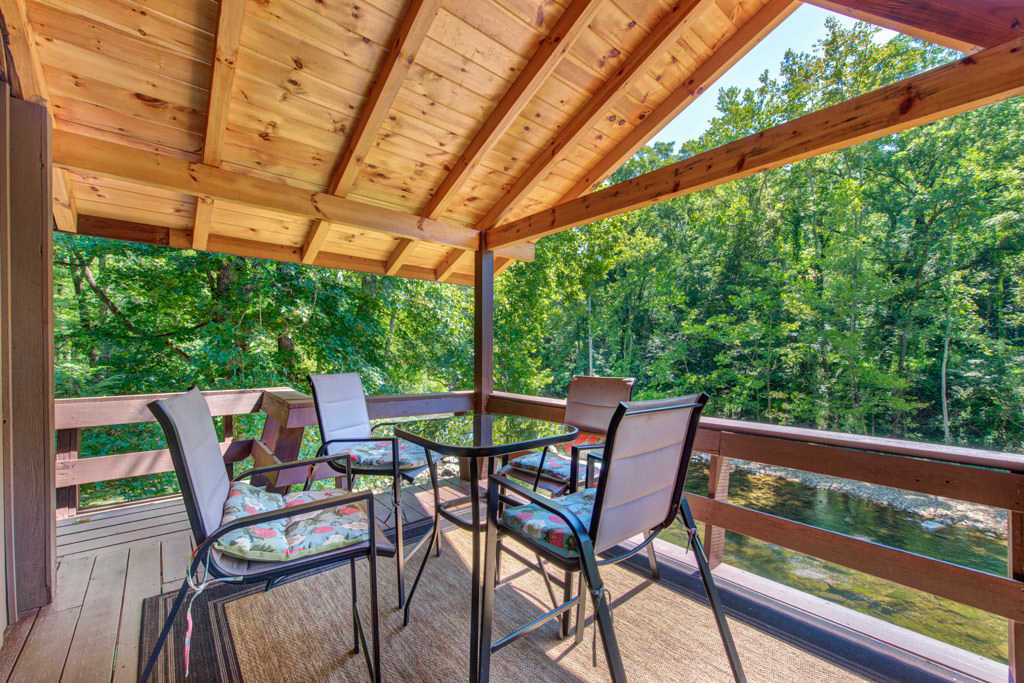 Top deck with outdoor dining furniture on the river