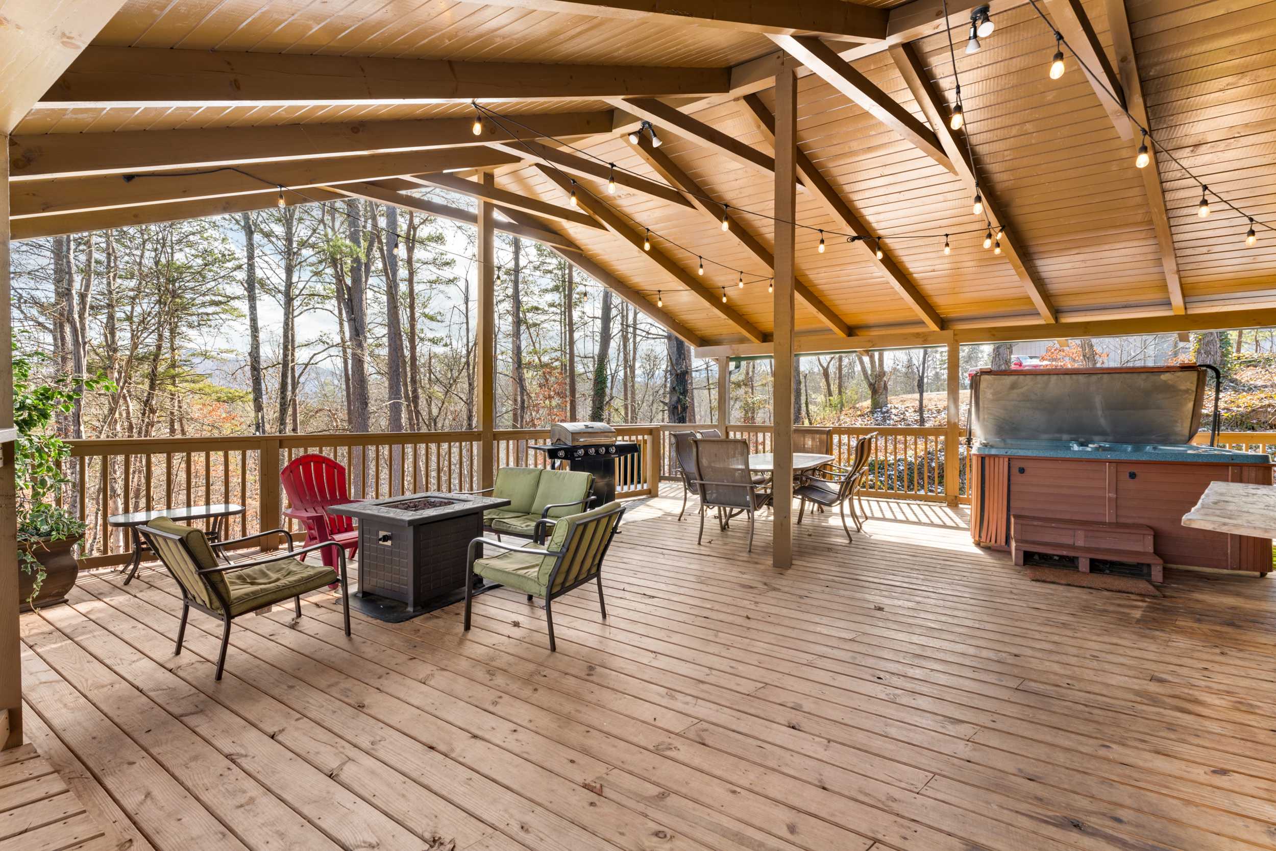 Unwind on the spacious deck with outdoor seating, firepit, grill, hot tub, and slide 