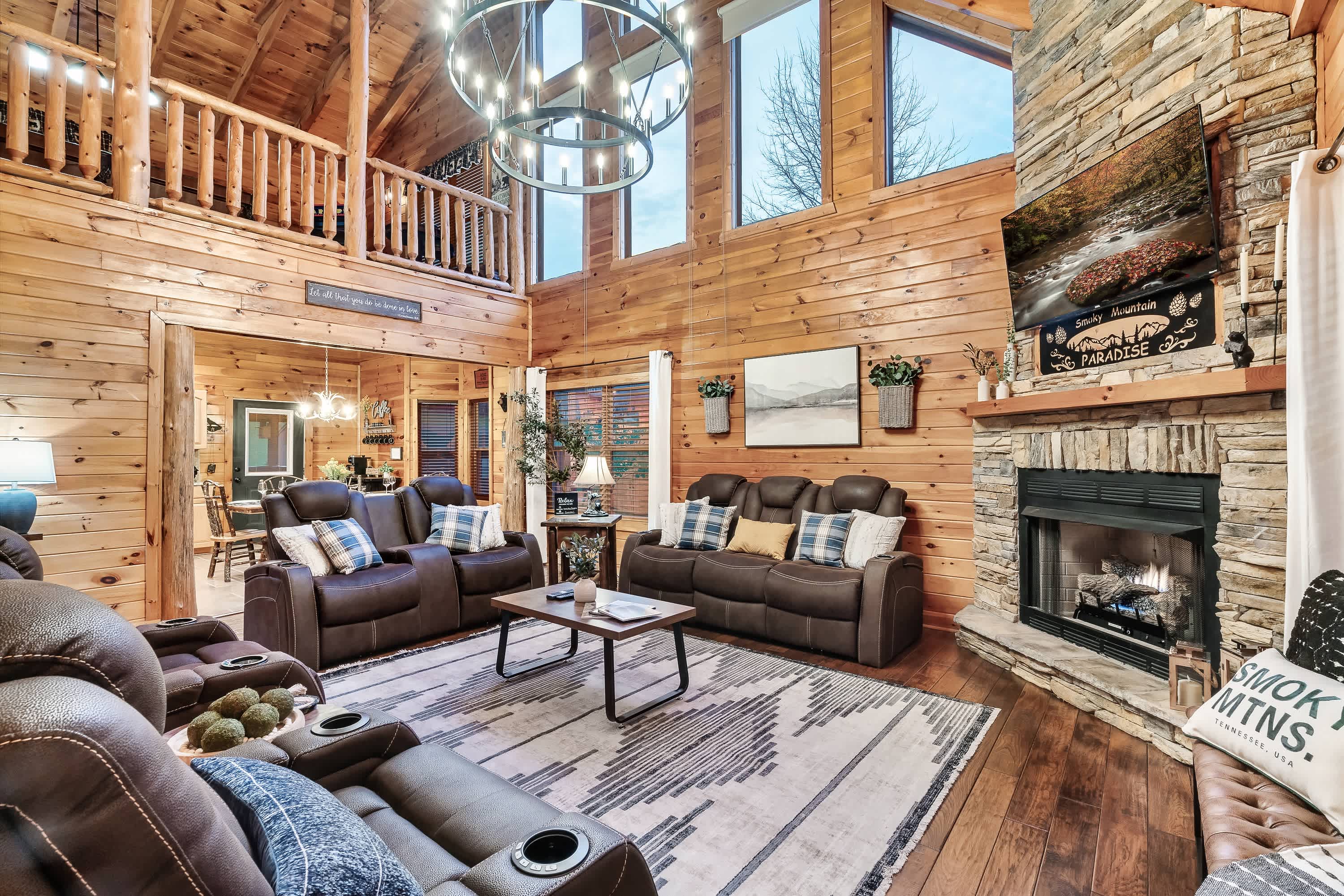 Bright open living area with reclining sofas, gas fireplace, and Smart TV