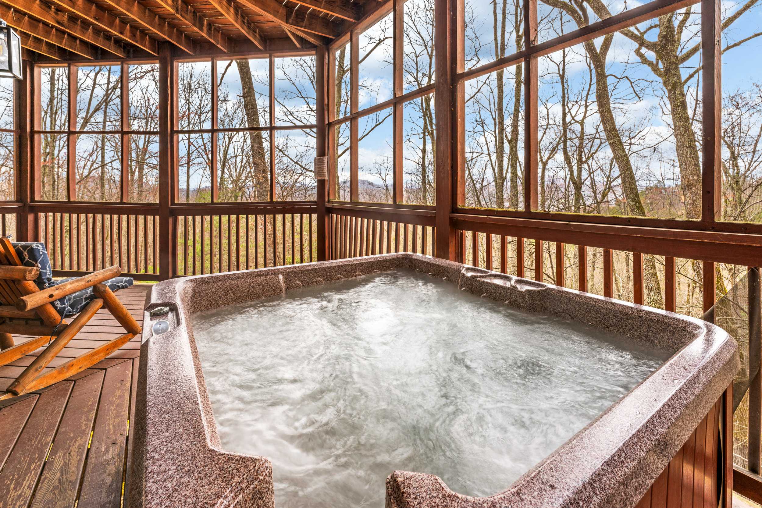 Screened in deck with hot tub and outdoor seating 
