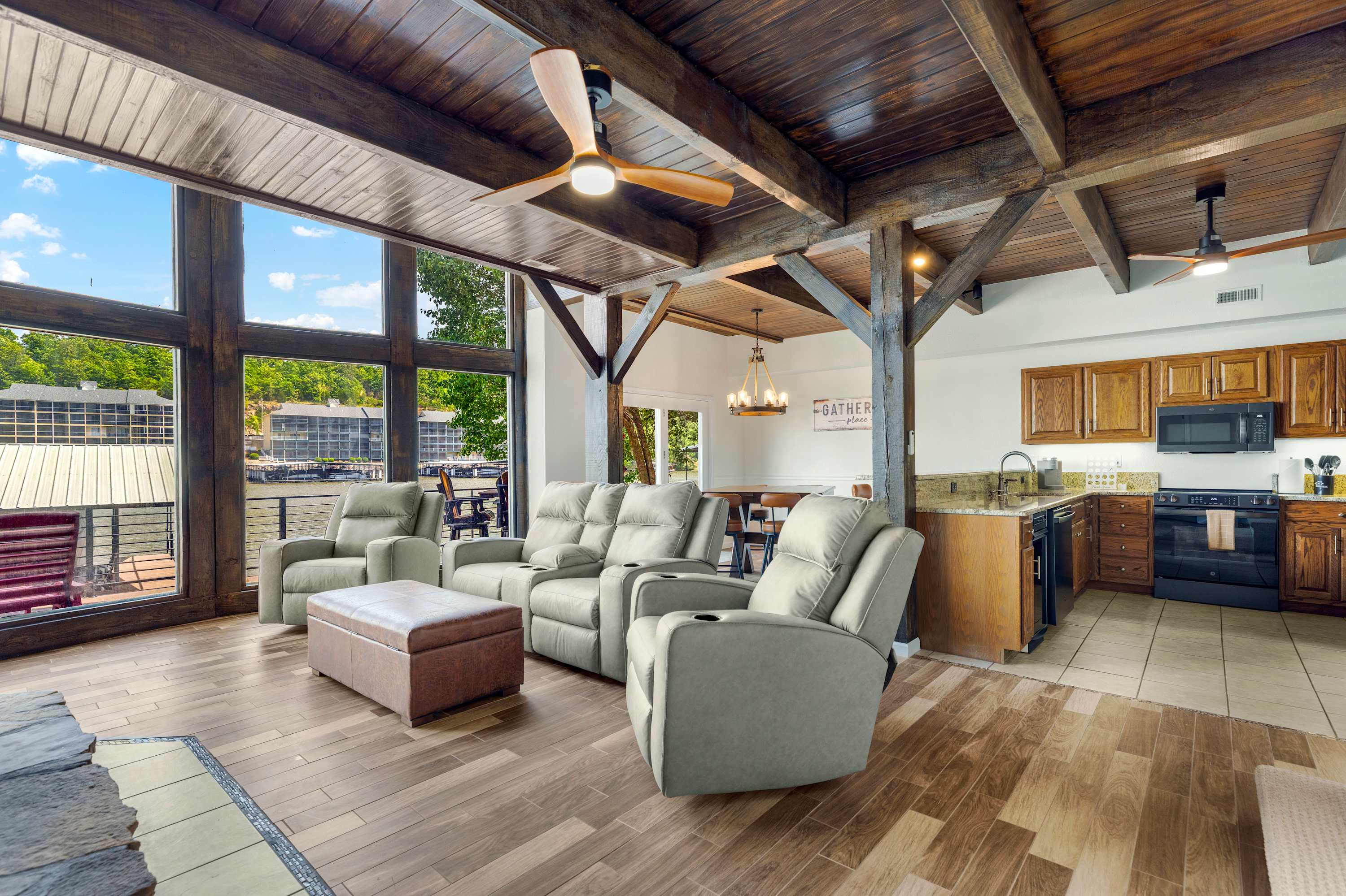 Spacious lower-level living room with big lakeview windows, seamlessly open to the kitchen and dining area—perfect for gathering, relaxing, and soaking in the view.