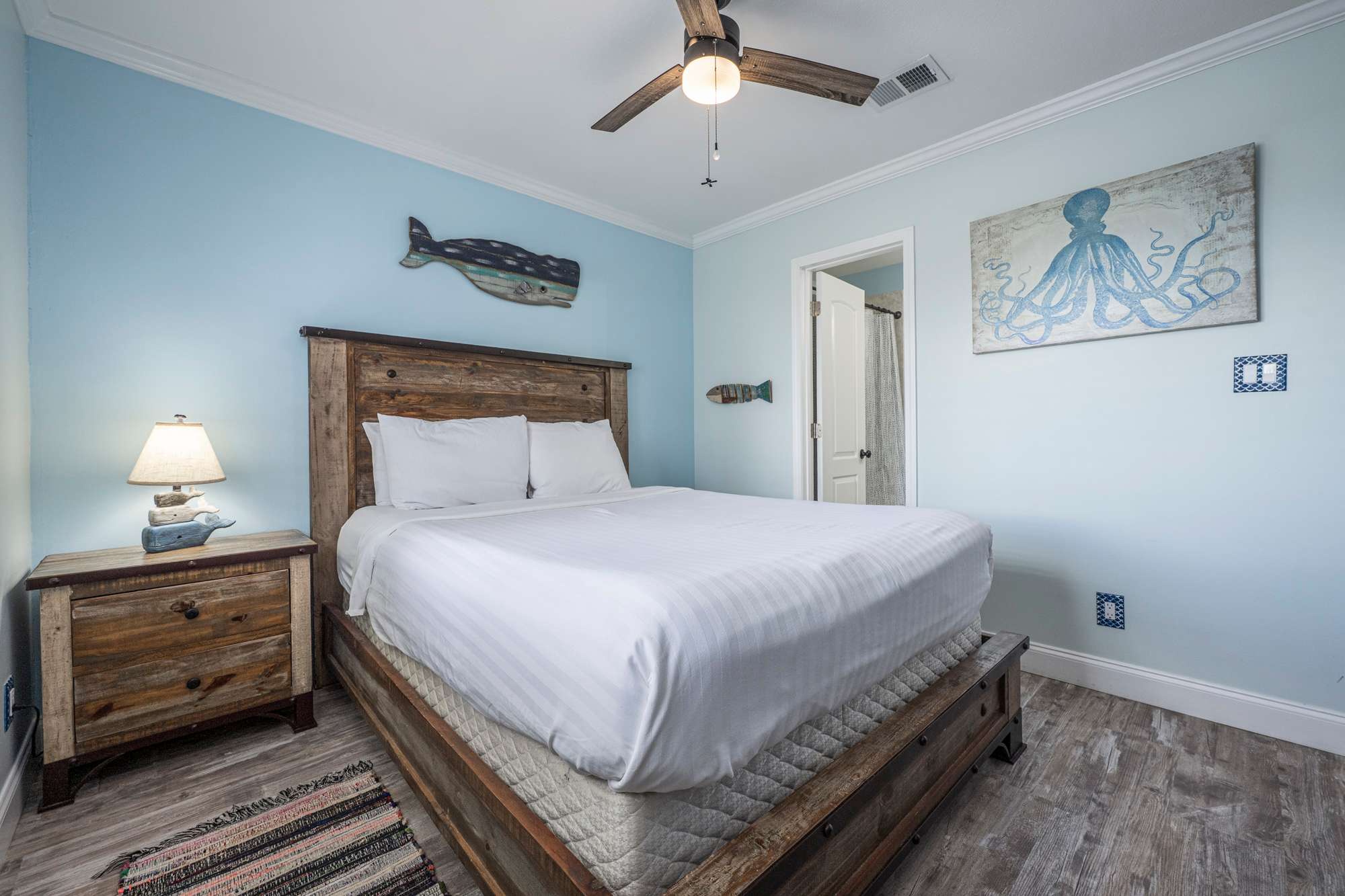 The serene bedroom features a plush queen bed & shared ensuite