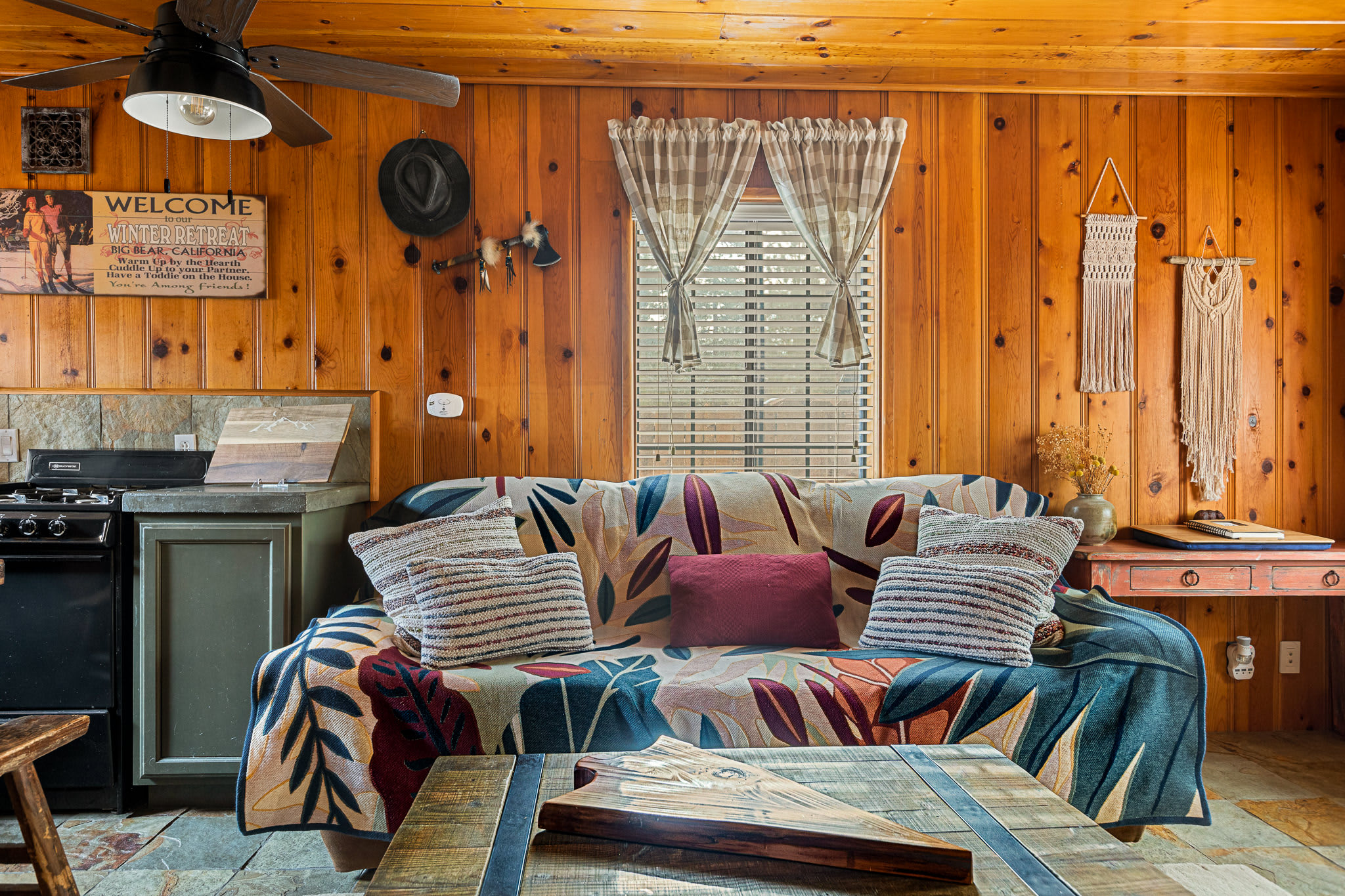 Open floor plan with comfy sofa, smart TV, and electric stove.