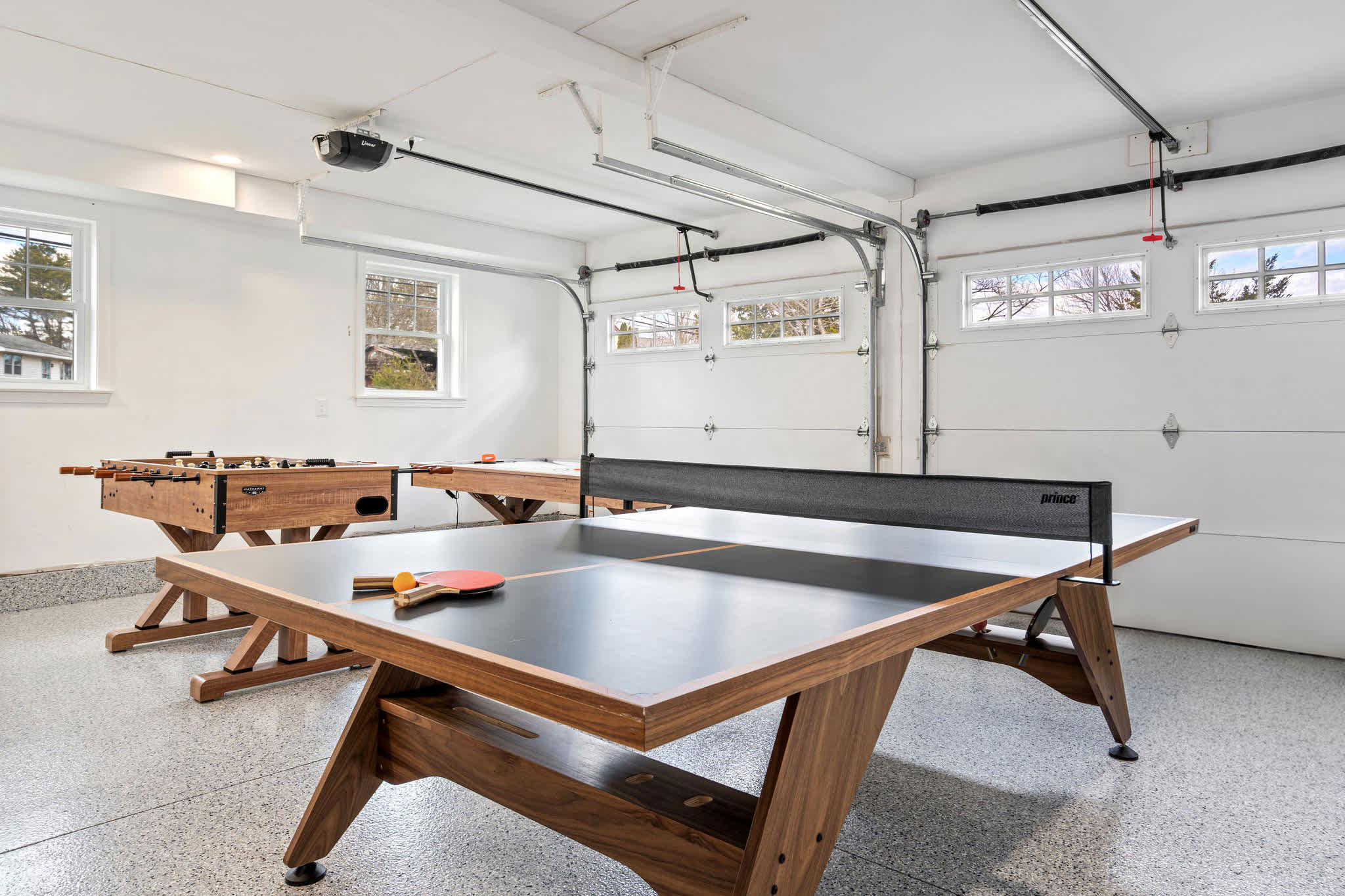 Garage/game room with ping pong, foosball, and air hockey table 