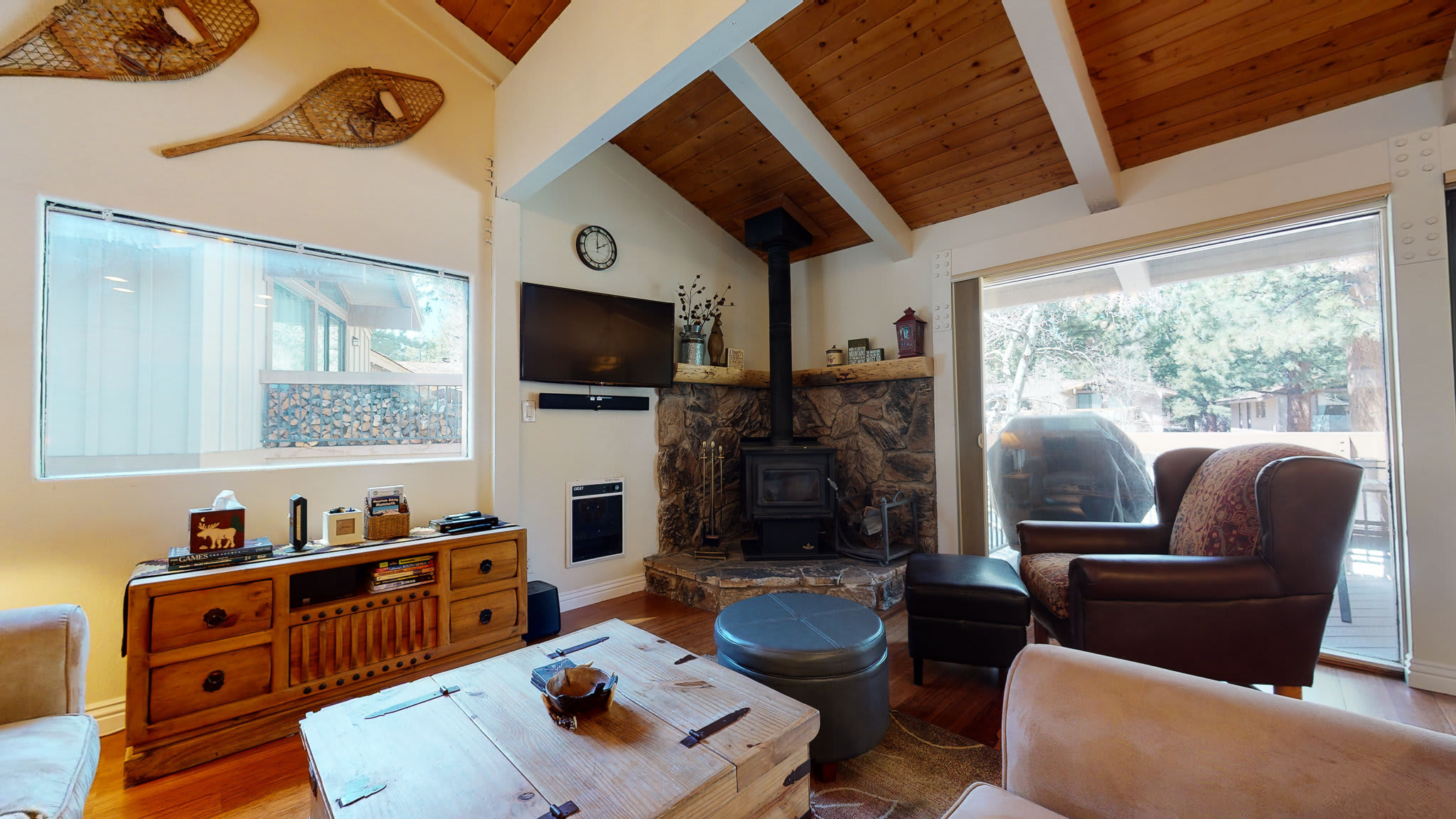 Cozy living space with fireplace, TV, and deck access