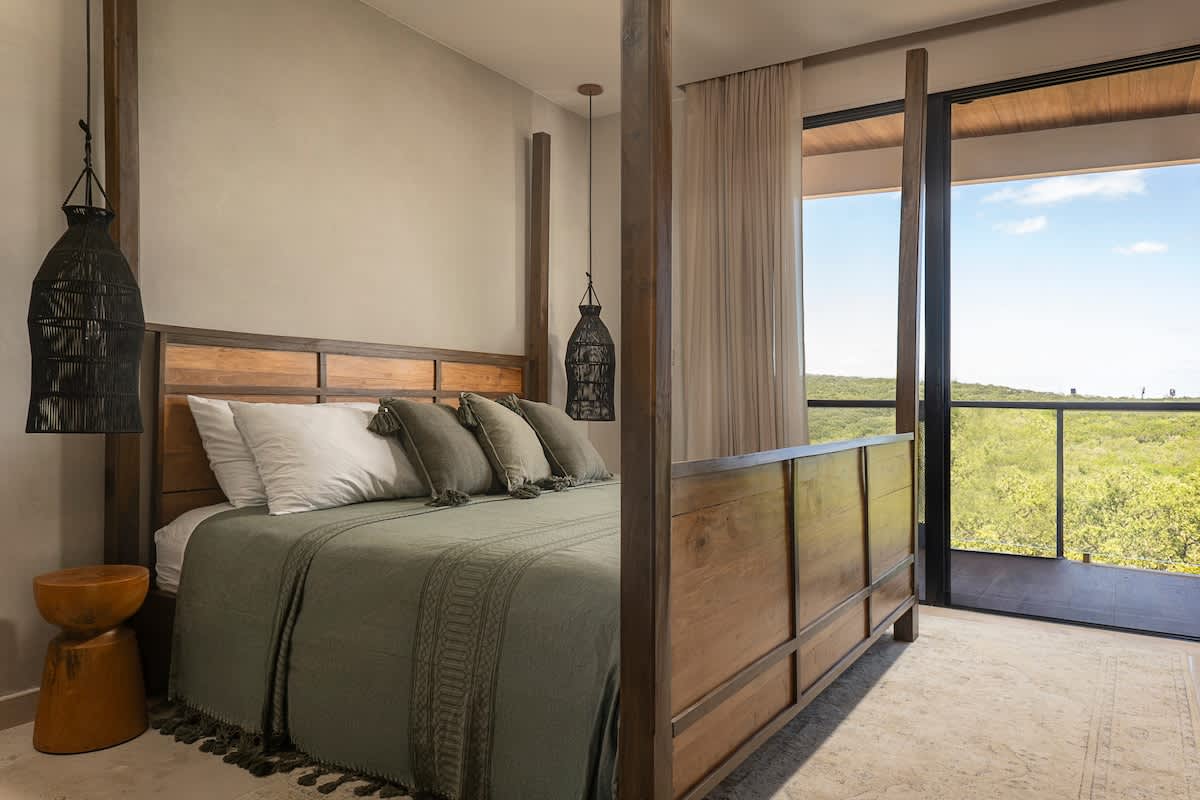 Bedroom with a tranquil jungle view, featuring a luxurious king-size bed 
