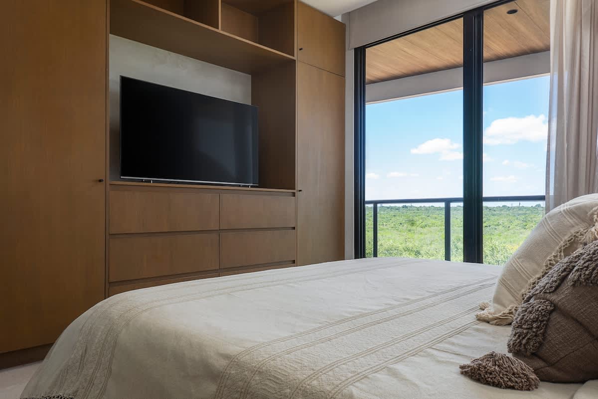Bedroom with a tranquil jungle view, featuring a luxurious king-size bed 
