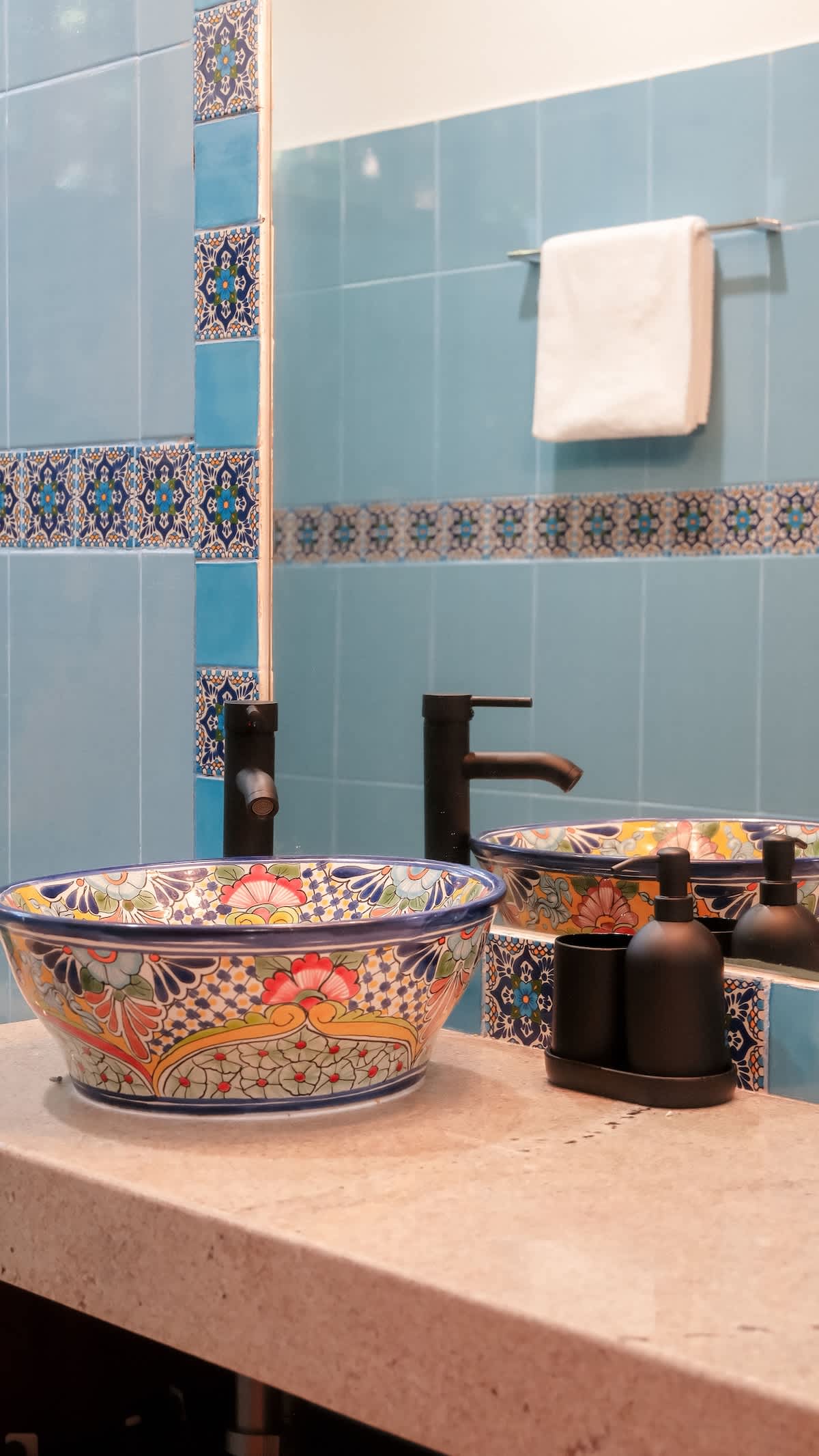 A beautifully crafted Mexican artisanal-style bathroom with hand-painted Talavera sinks, colorful tiles, and unique handmade details.