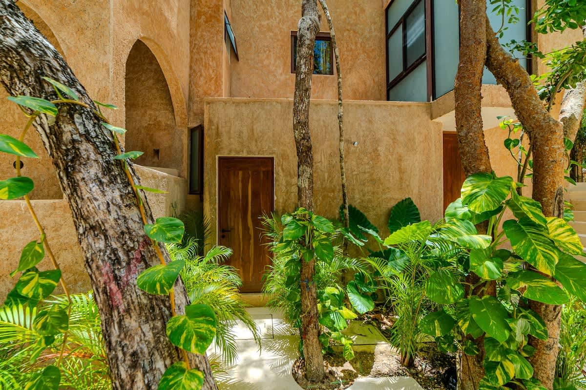 A peaceful jungle pathway welcomes you to the penthouse, blending modern design with Tulum’s natural surroundings.