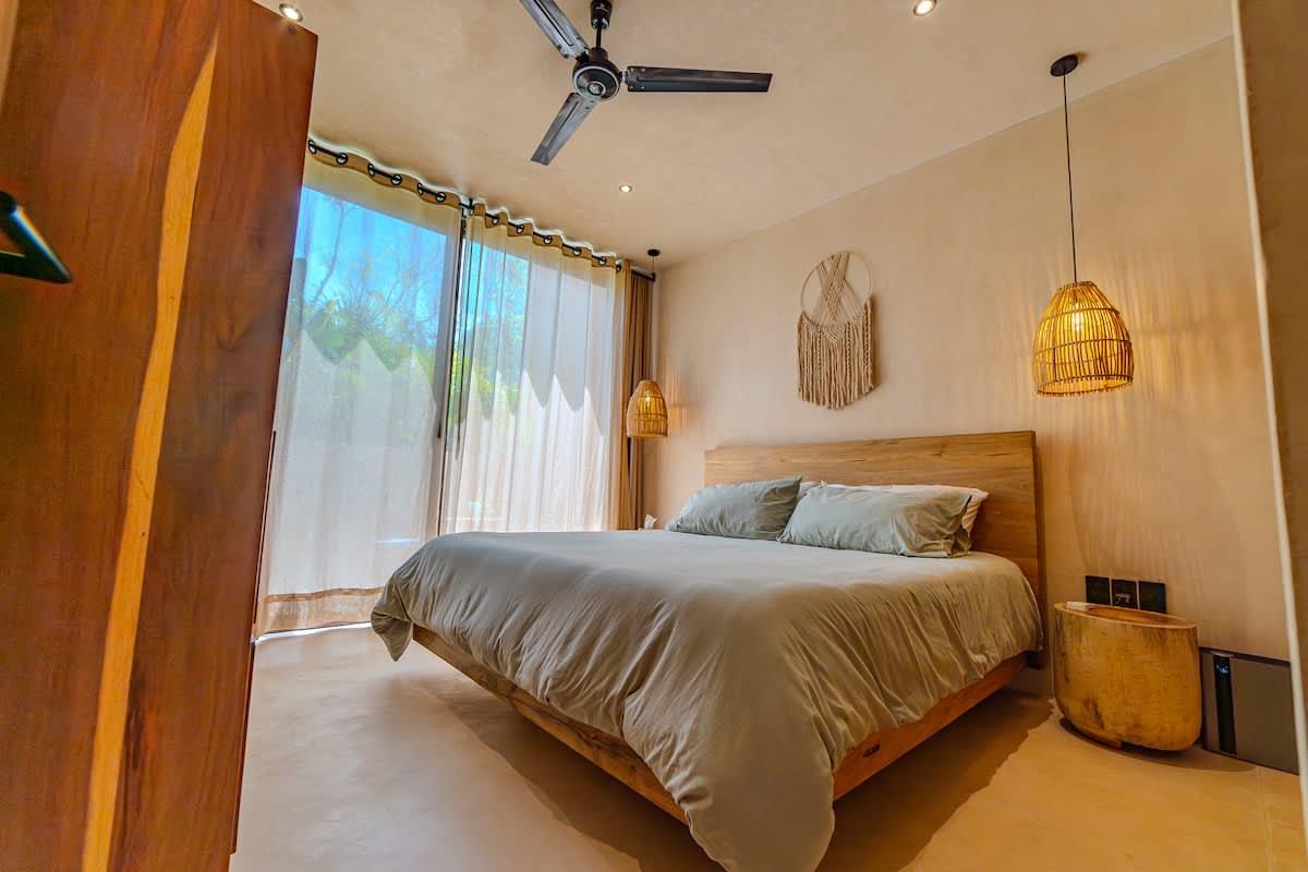 1 King size bed -Peaceful bedroom designed for comfort, featuring a cozy bed and calming jungle surroundings.