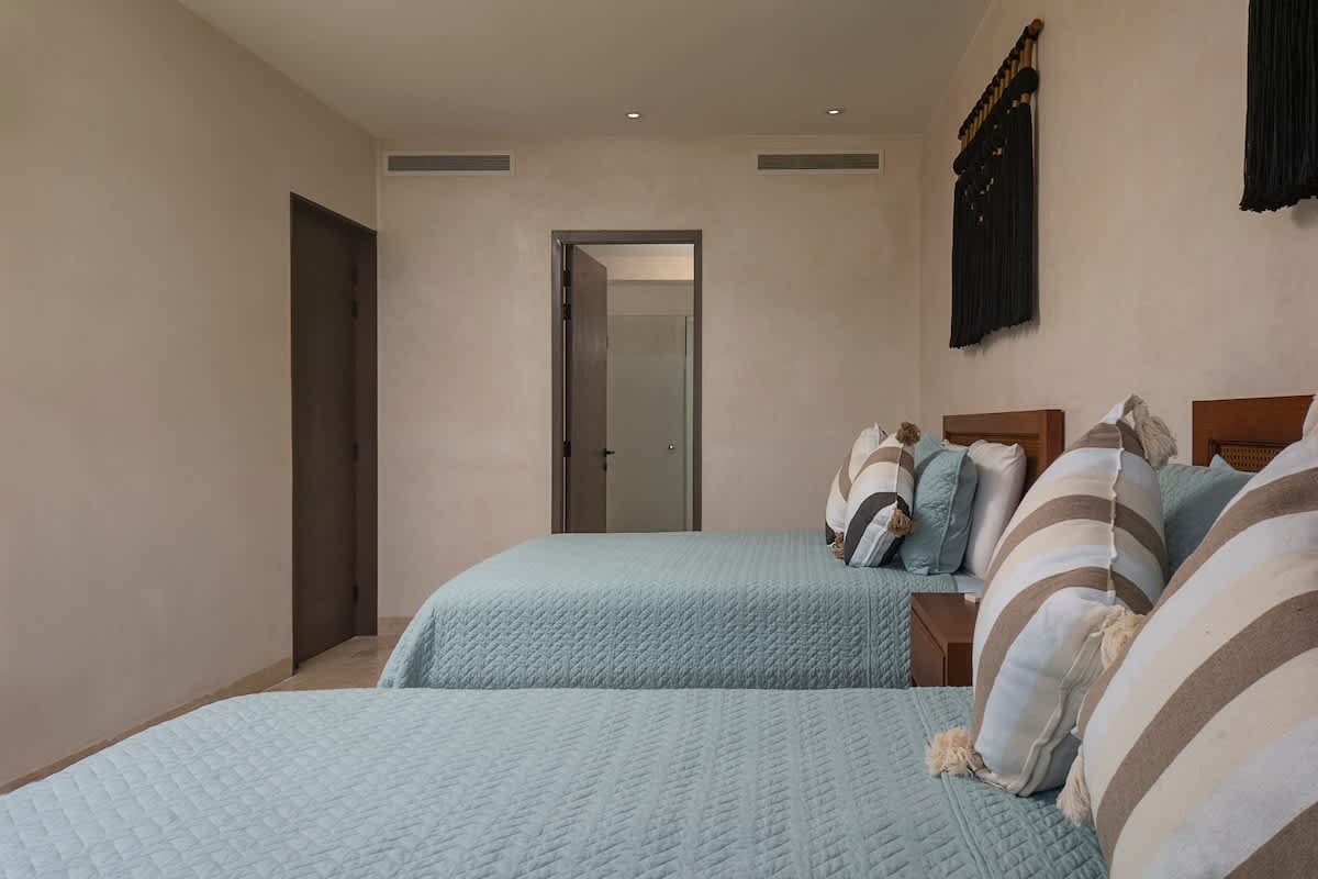 Bedroom #6 features two comfortable queen beds and beautiful jungle views, creating the perfect relaxing retreat.