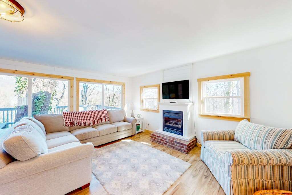 Tree-lined lake view abode with large deck, modern interior, board games, & W&D