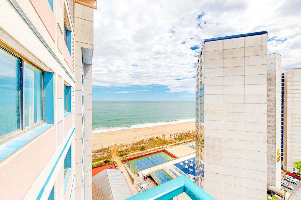 Bright coastal condo with pool access, side views of the ocean, balcony & washer & dryer