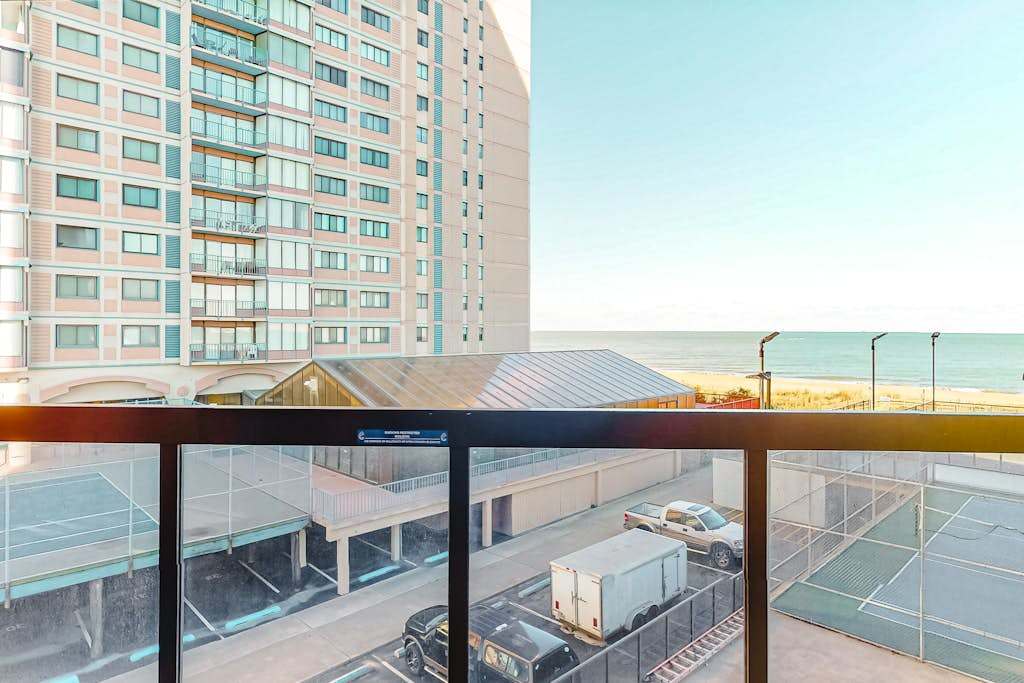 Light-filled beach condo with balcony, AC, angled views, pools, gym & sauna