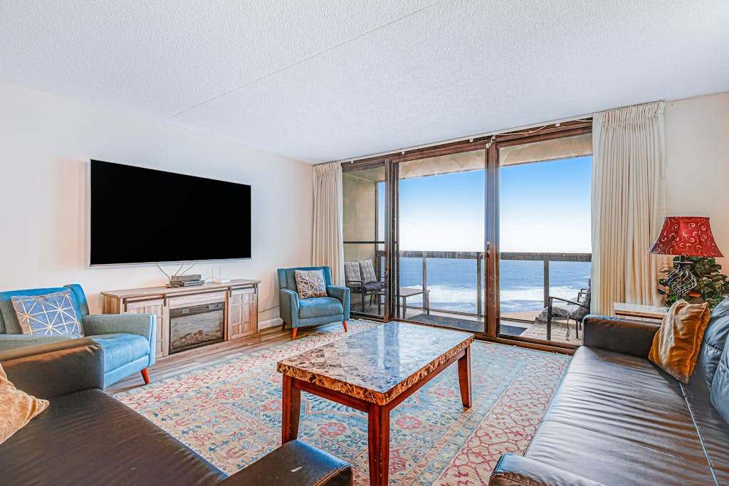 Convenient beachfront condo with angled views, cozy balcony, pools, gym & tennis