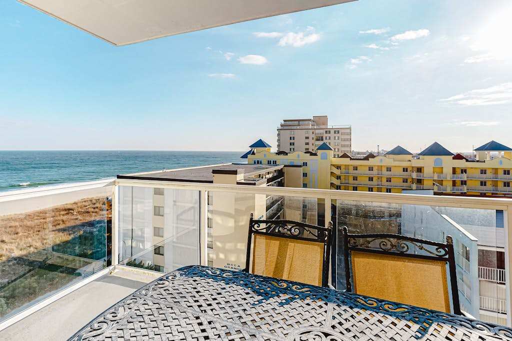 Ocean-view condo with shaded balcony, central AC, washer & dryer, pool, gym & coastal decor