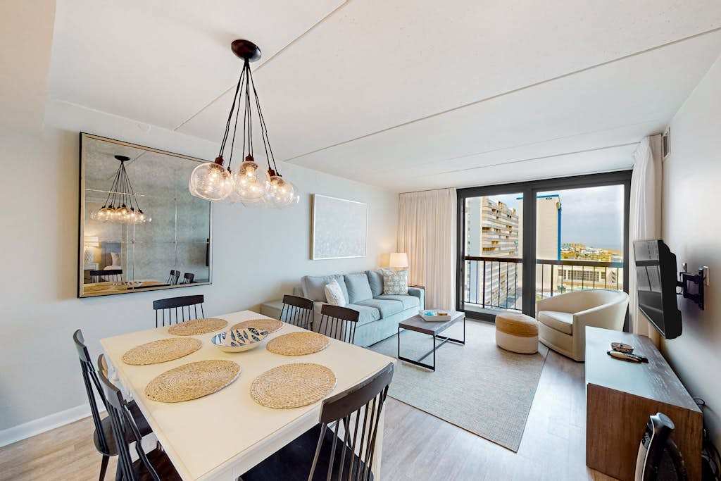 Beachfront condo with wrap-around balcony, modern interior, pools, & gym