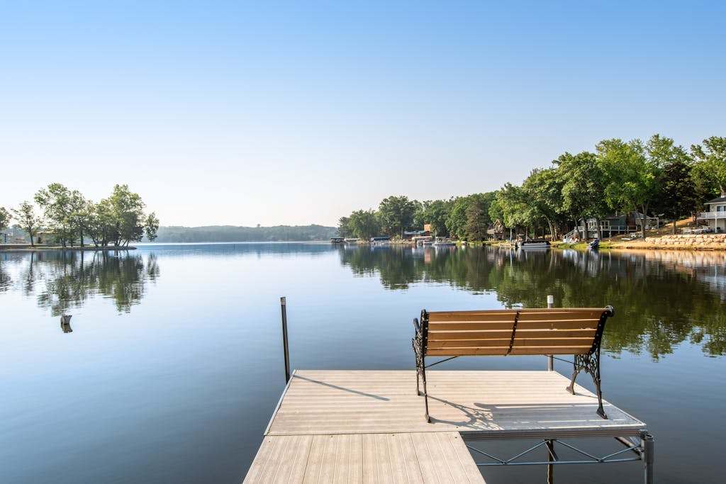 Lakefront condo with beach access, firepit, games, fireplace, & dock