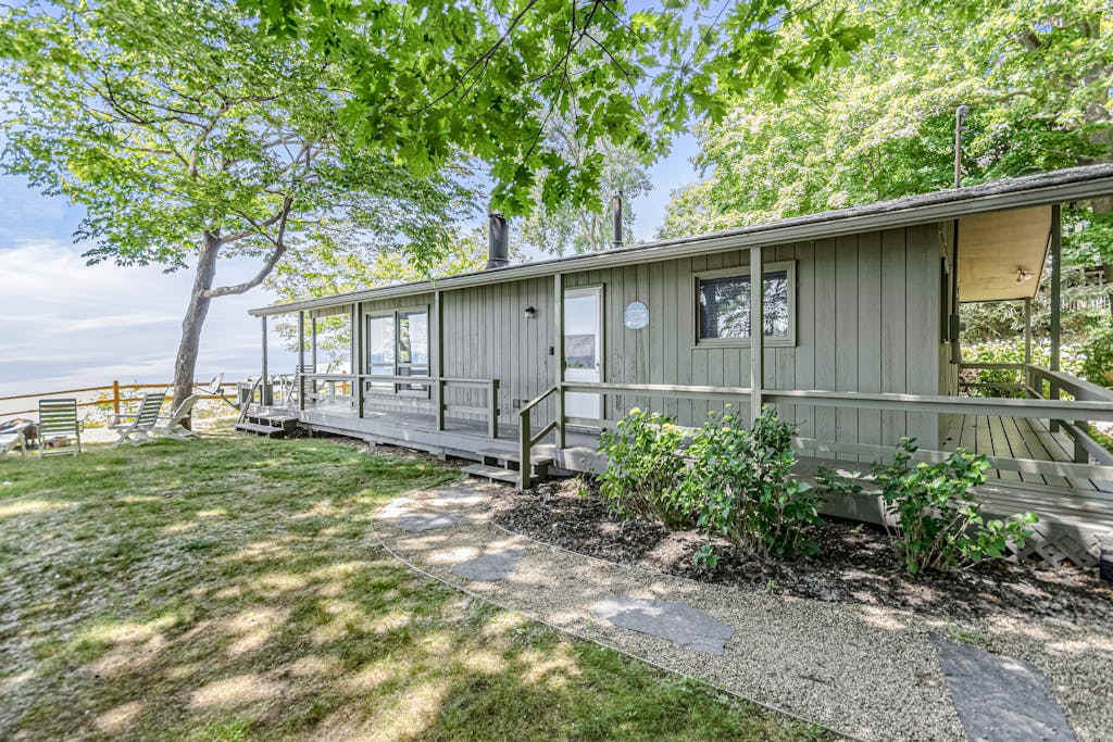 Quaint lakefront cottage with private hot tub, firepit, & beautiful sunset views