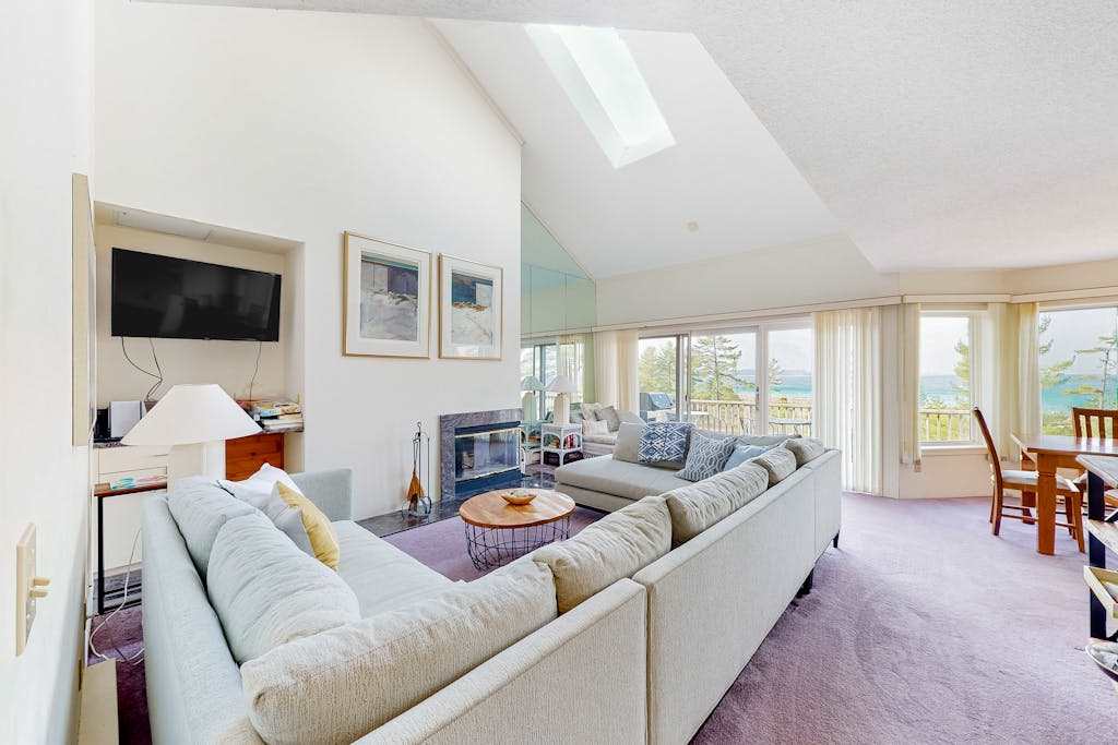 Sunny upper-level beachfront condo with Lake Michigan views, fireplace, deck