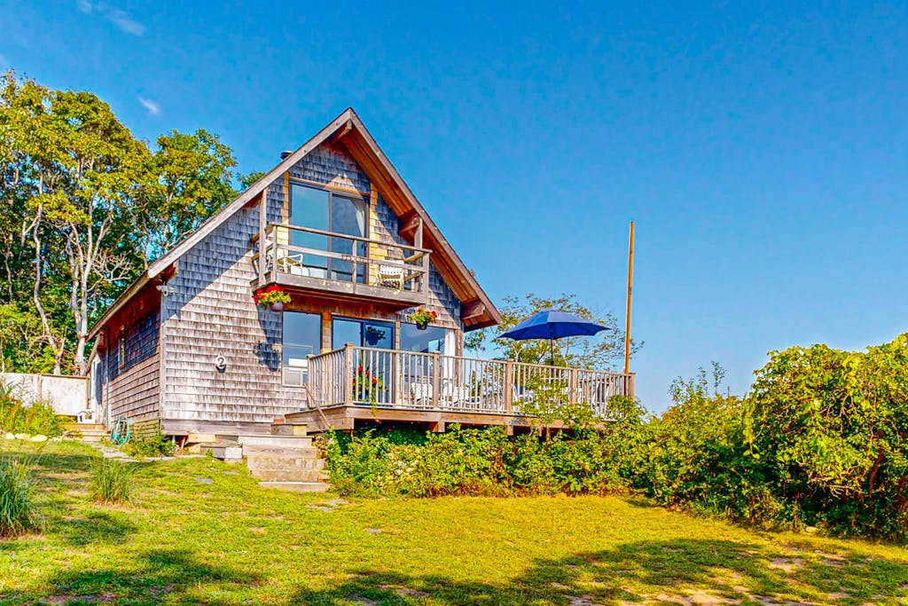 Water-view home with large deck, balcony, enclosed sunroom & peaceful location