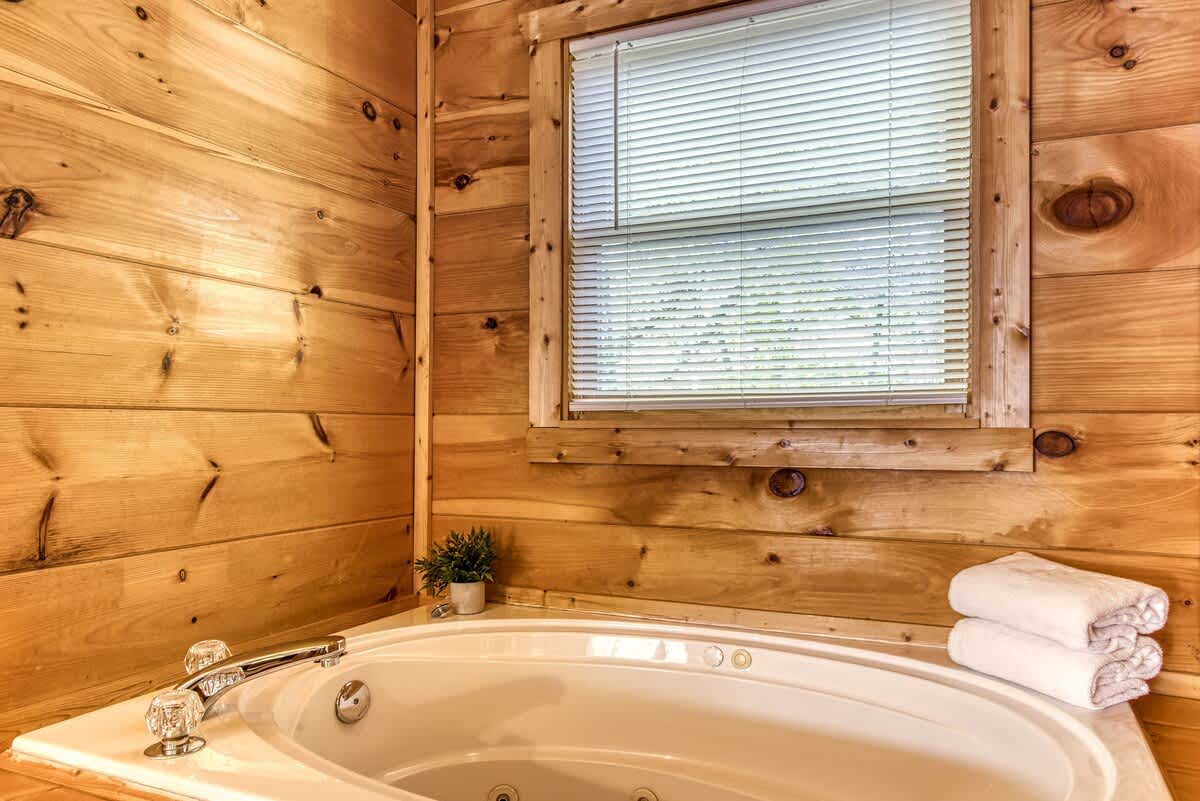 Unwind in a luxurious tub surrounded by warm wooden walls and natural light!