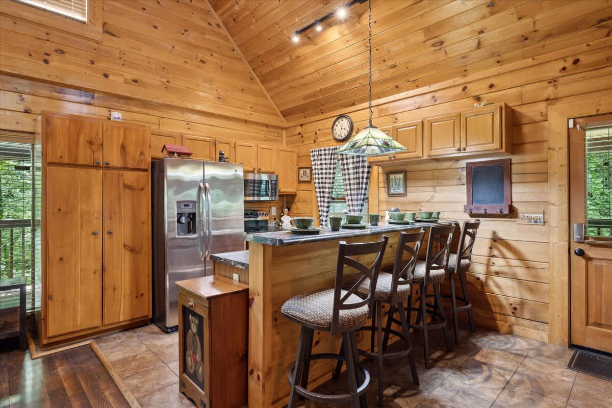 Gather around the stylish bar for meals and laughter in this charming wooden kitchen!