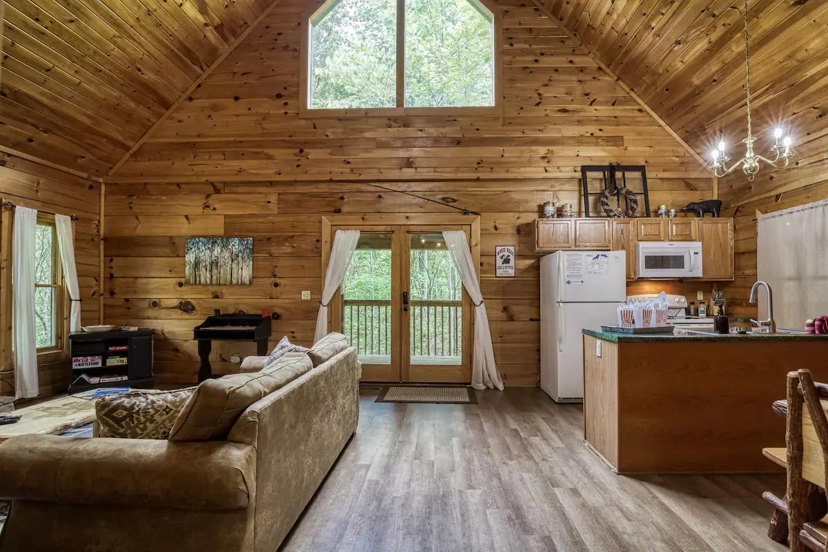 Living Room: Sunlit space with wooden charm and kitchen access, perfect for gathering and fun!