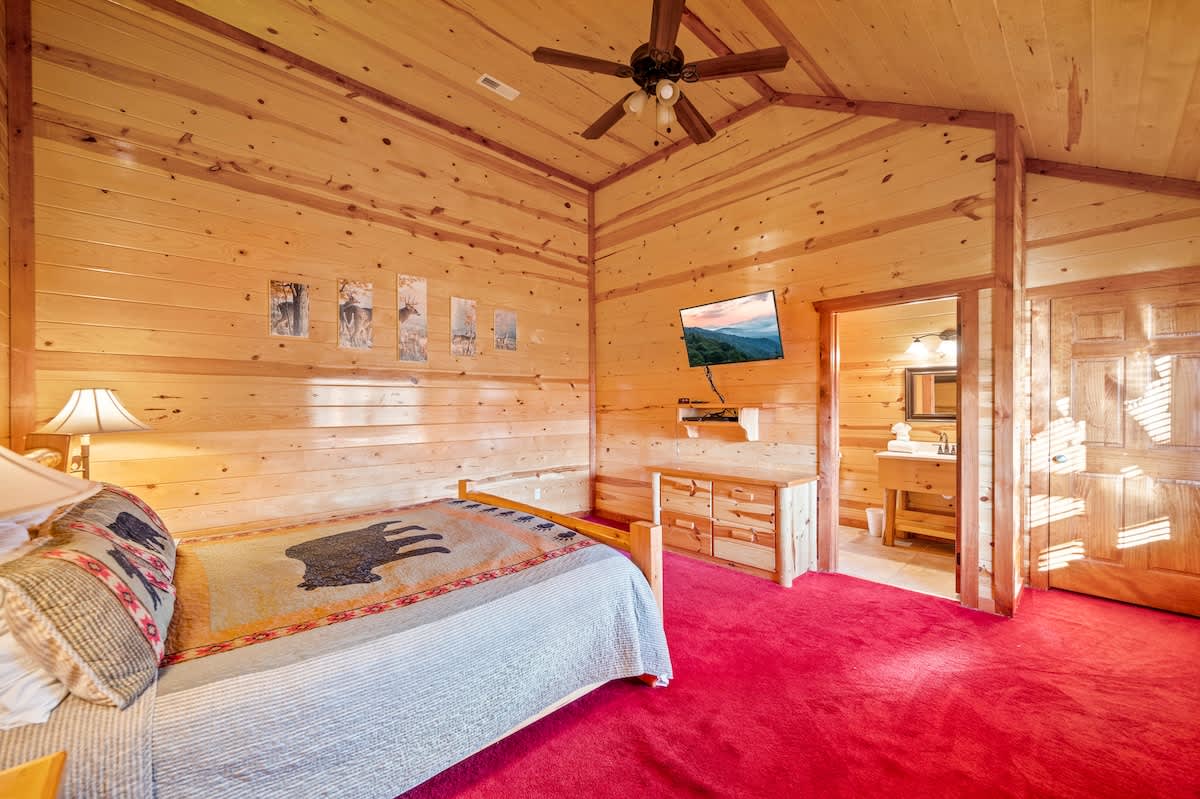 Rustic charm with a mountain view, cozy bed, and warm wooden accents!