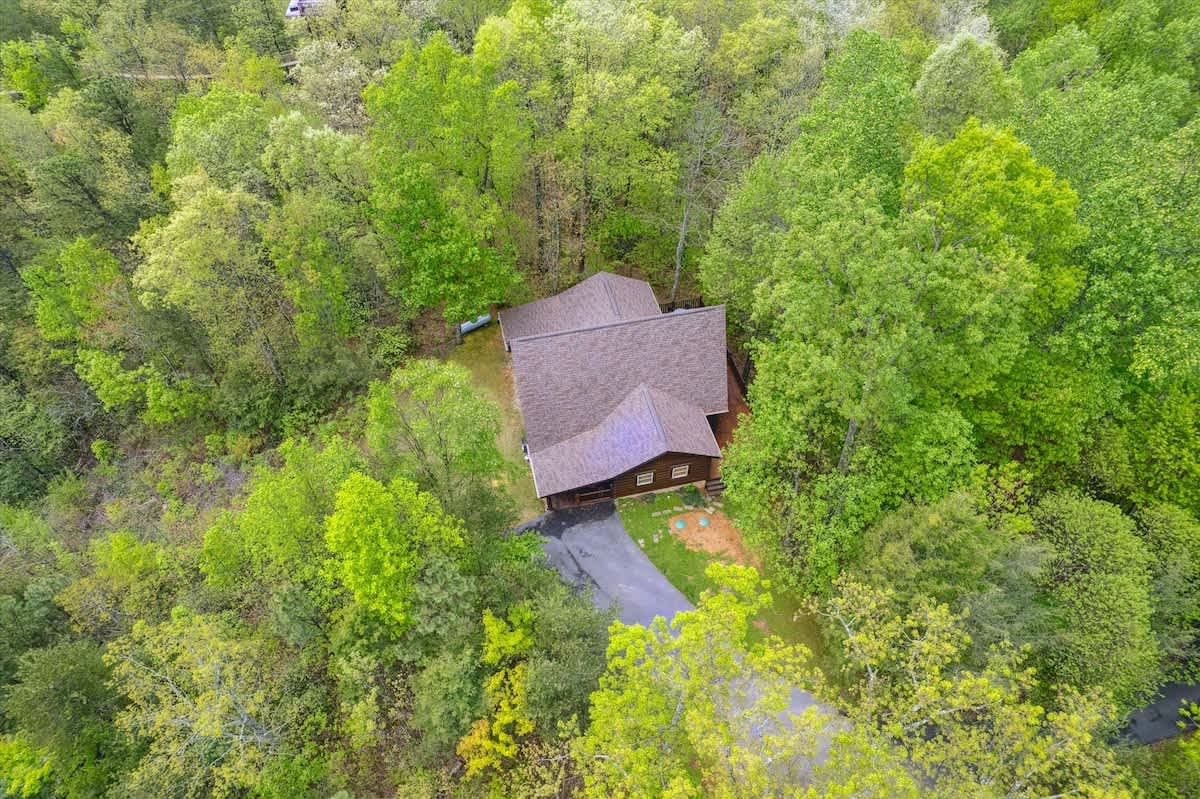 Exterior: Nestled in lush greenery, this charming cabin is your gateway to Gatlinburg adventures!