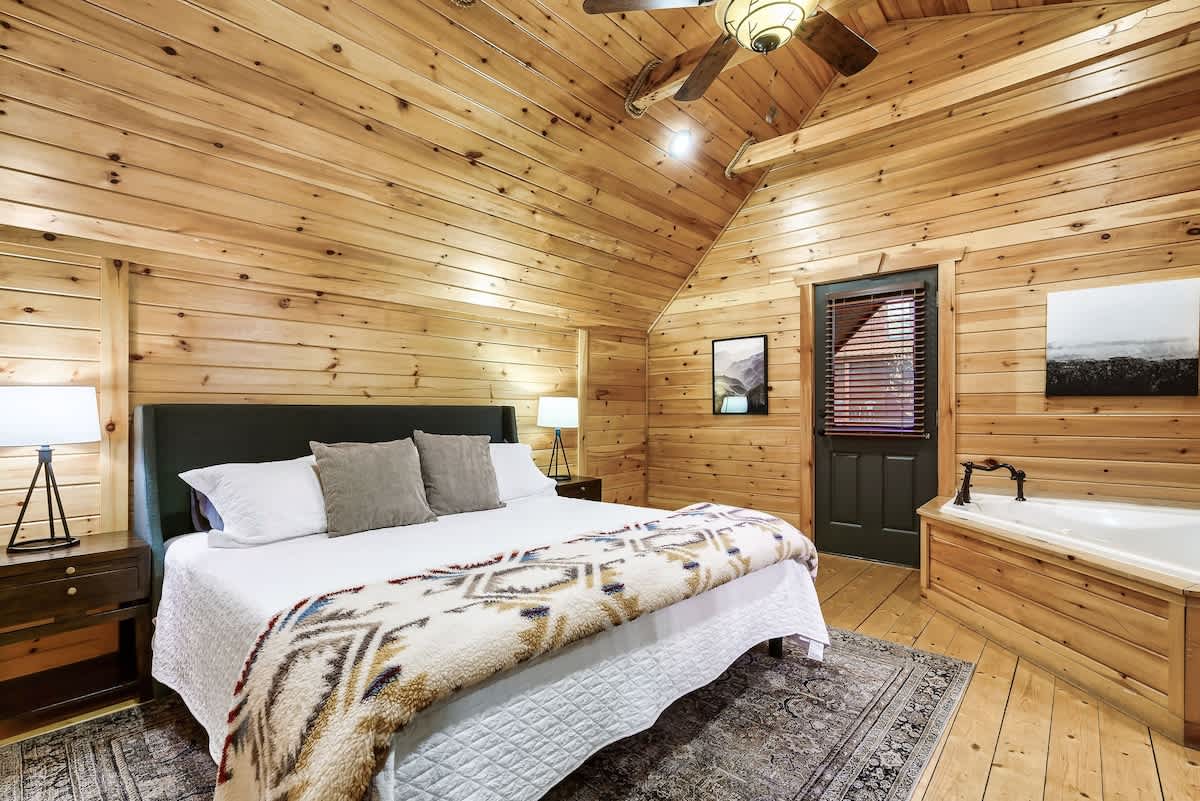 Primary Suite: Spacious room with rustic charm, king bed, and a relaxing soaker tub for ultimate unwind!