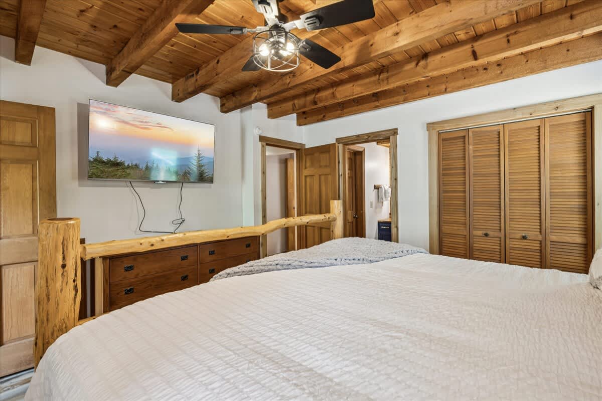 Rest easy in this serene bedroom retreat—plush bedding and peaceful forest views